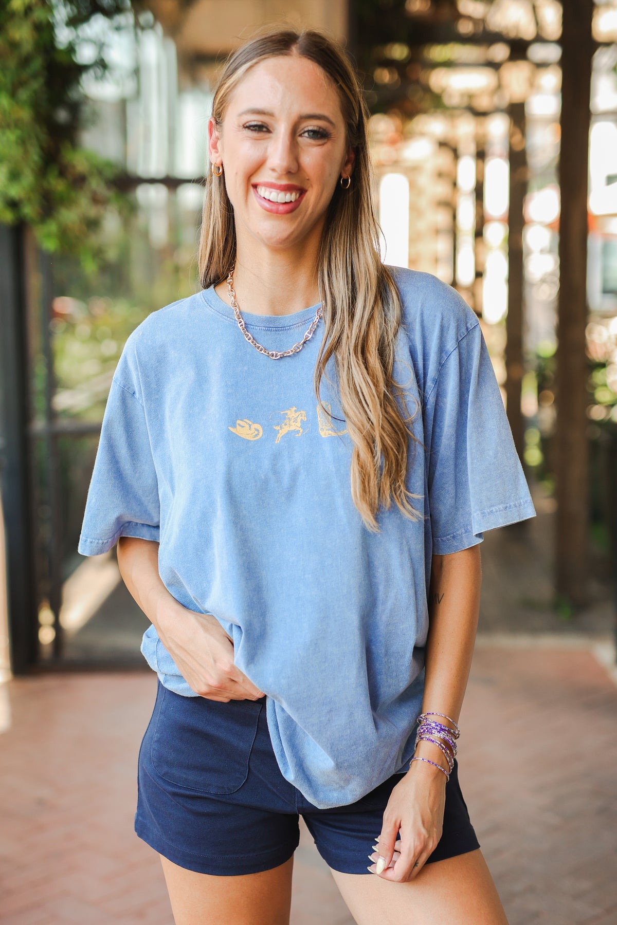 Woman wearing a blue t-shirt with a graphic design outdoors