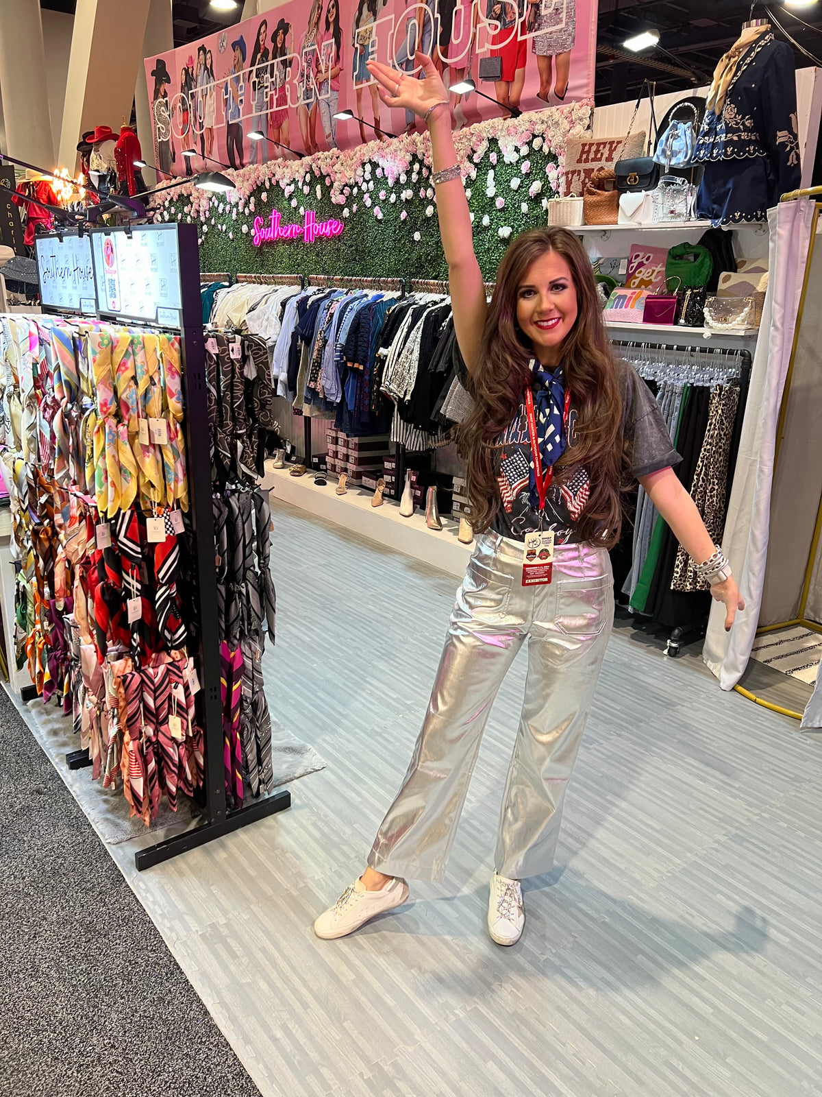 Woman in a store with clothing racks and a 'Southern House' sign in the background | Southern House Clothing