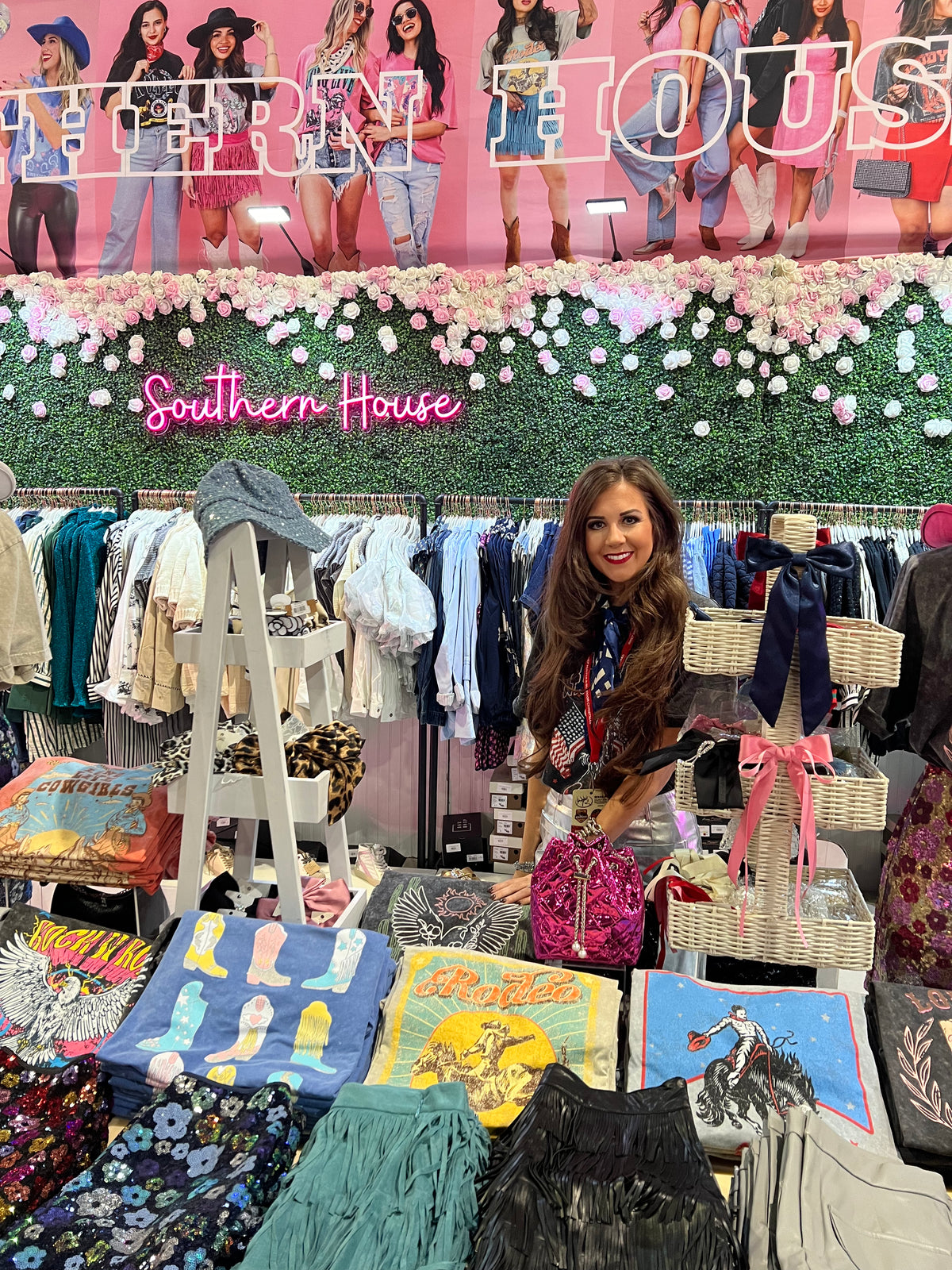 Woman standing in a store with clothing and decor items, featuring Southern House Clothing