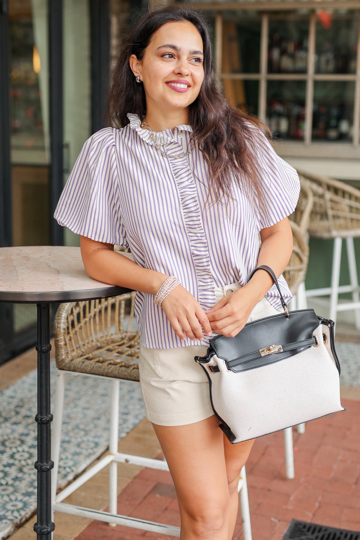 Woman holding a handbag in an outdoor setting