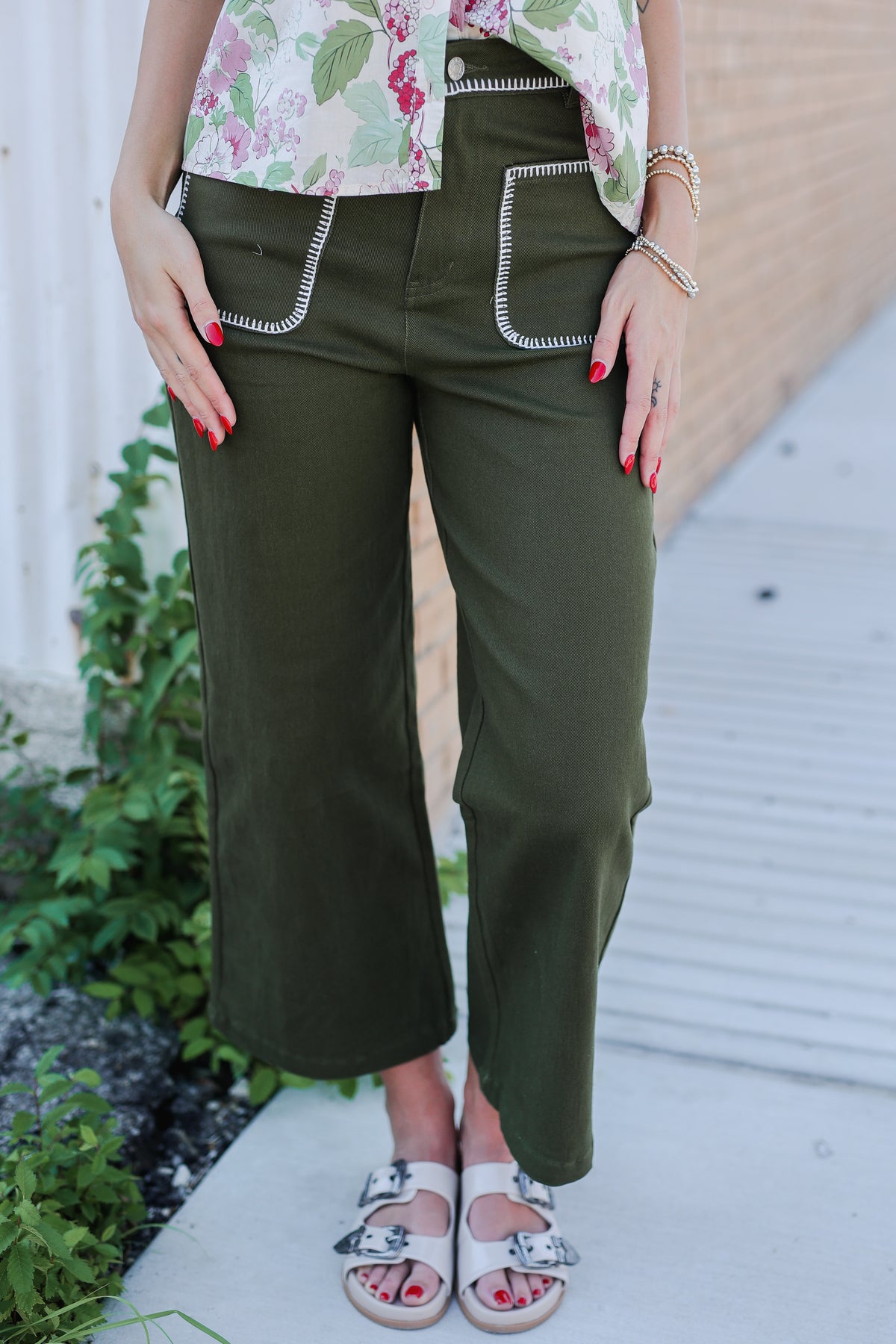 Person wearing green pants with white trim, standing outdoors.