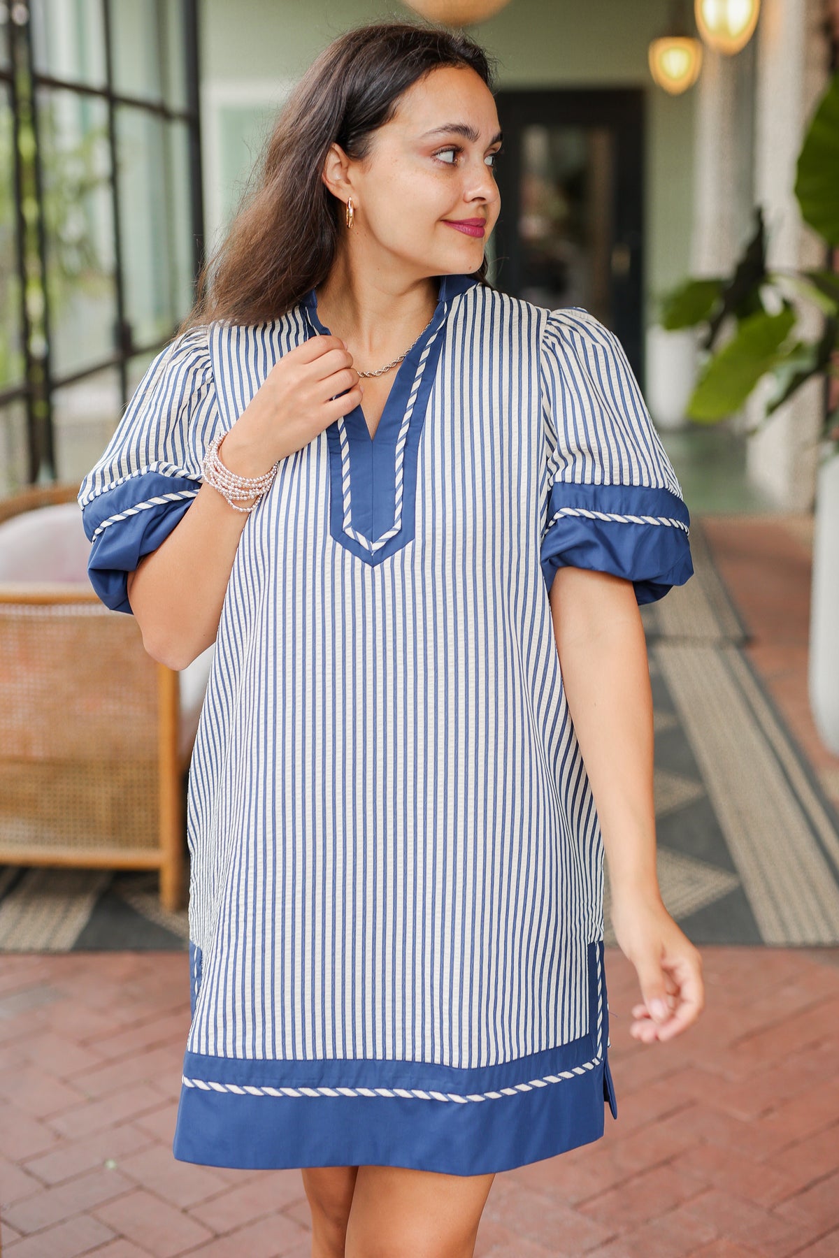 Woman wearing a blue and white striped dress with a blurred background