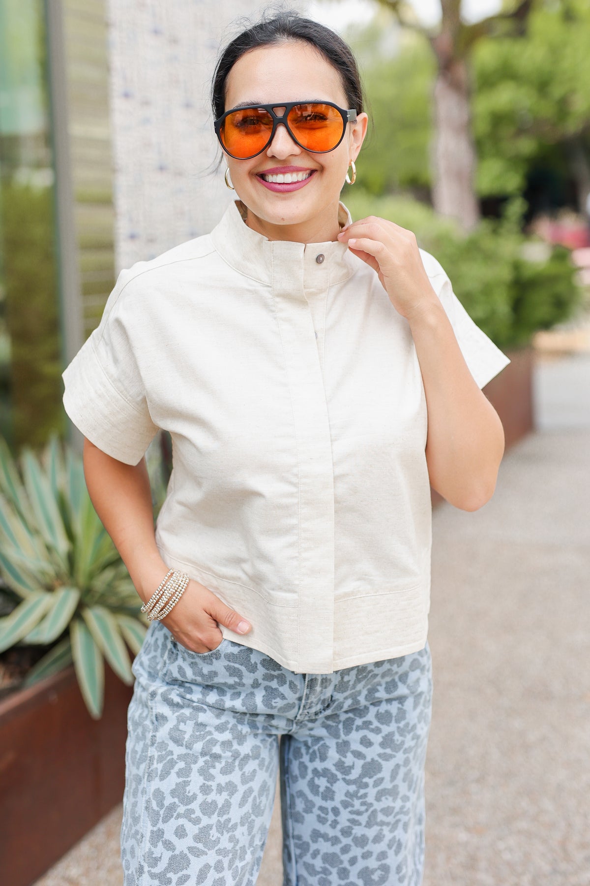 Woman wearing a white blouse and patterned pants outdoors