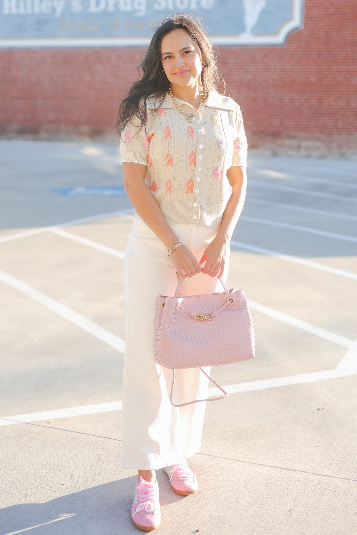 Woman holding a pink handbag on a basketball court