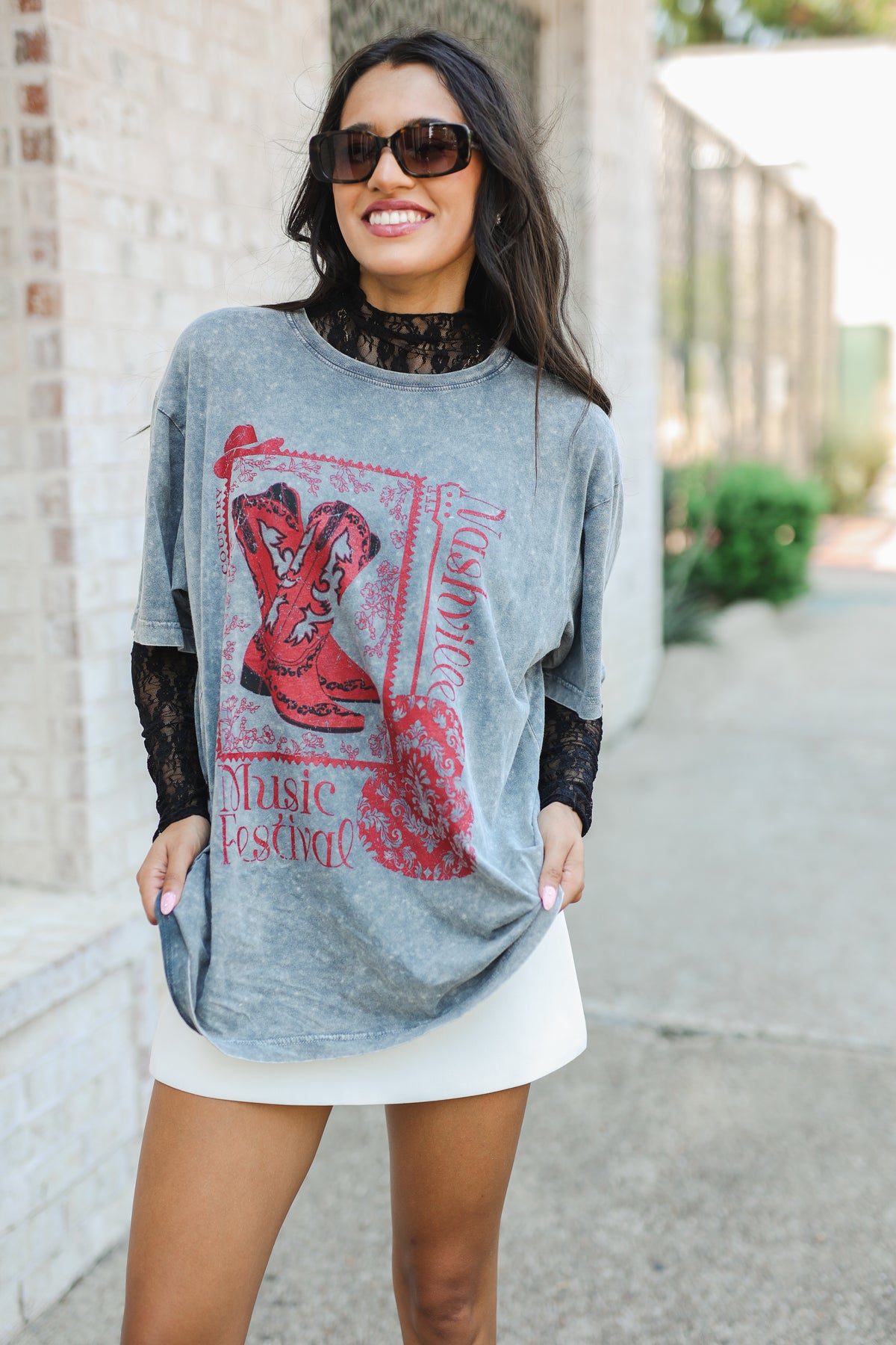 Woman wearing a gray oversized t-shirt with red graphic design outdoors.