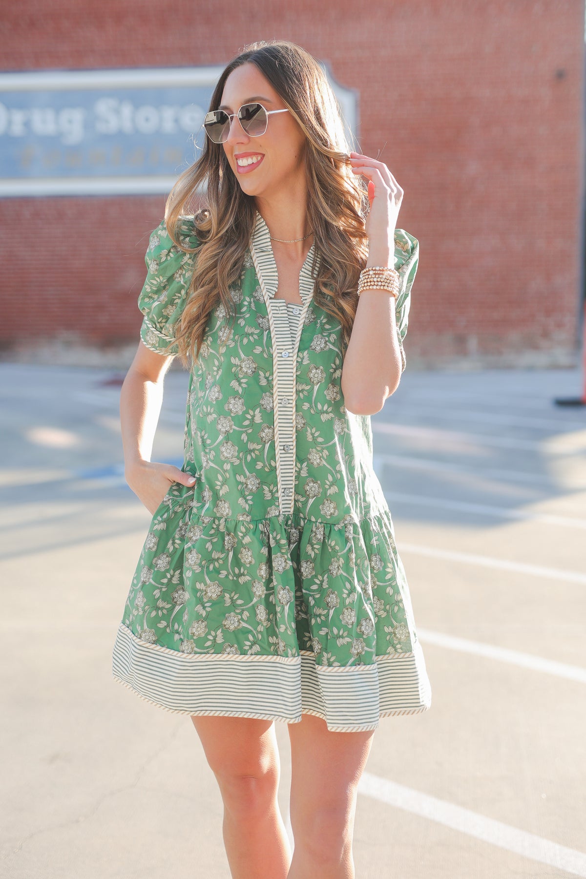 Woman wearing a green floral dress with a blurred background