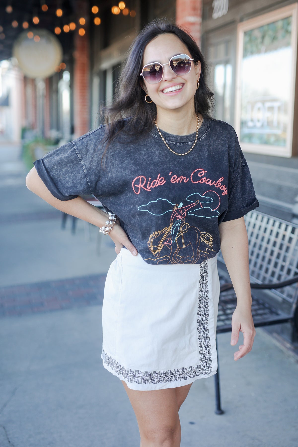 Woman wearing a graphic t-shirt and white skirt outdoors