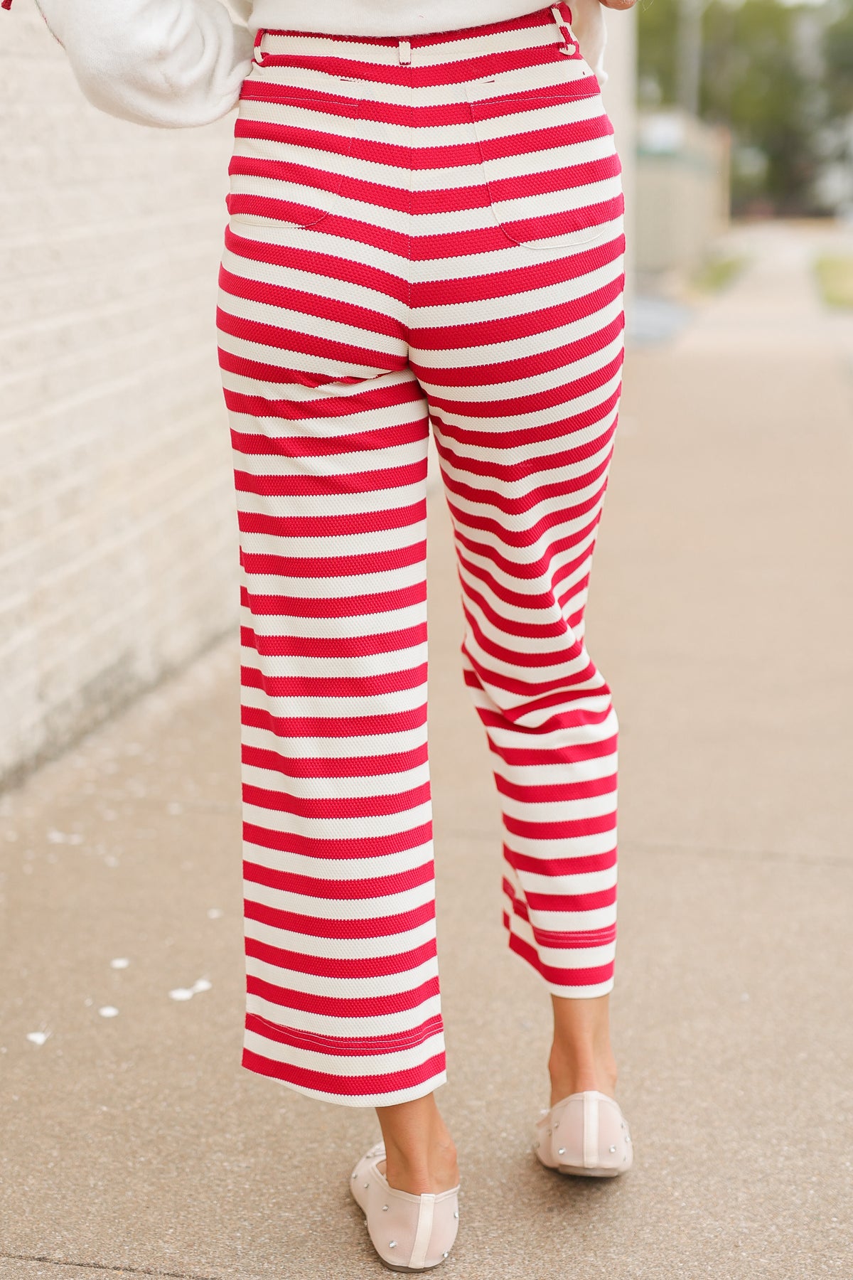 Close up of the Candy Cane Lane Stripe Knit Pants in red and cream featuring bold horizontal stripes, high-rise waistband, front button closure, belt loops, and straight-leg fit. Southern House Clothing