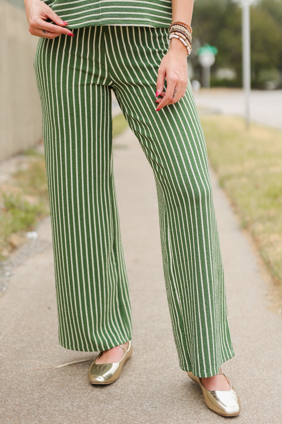 Close up of the pants of an olive set worn by a model outside. Southern House Clothing