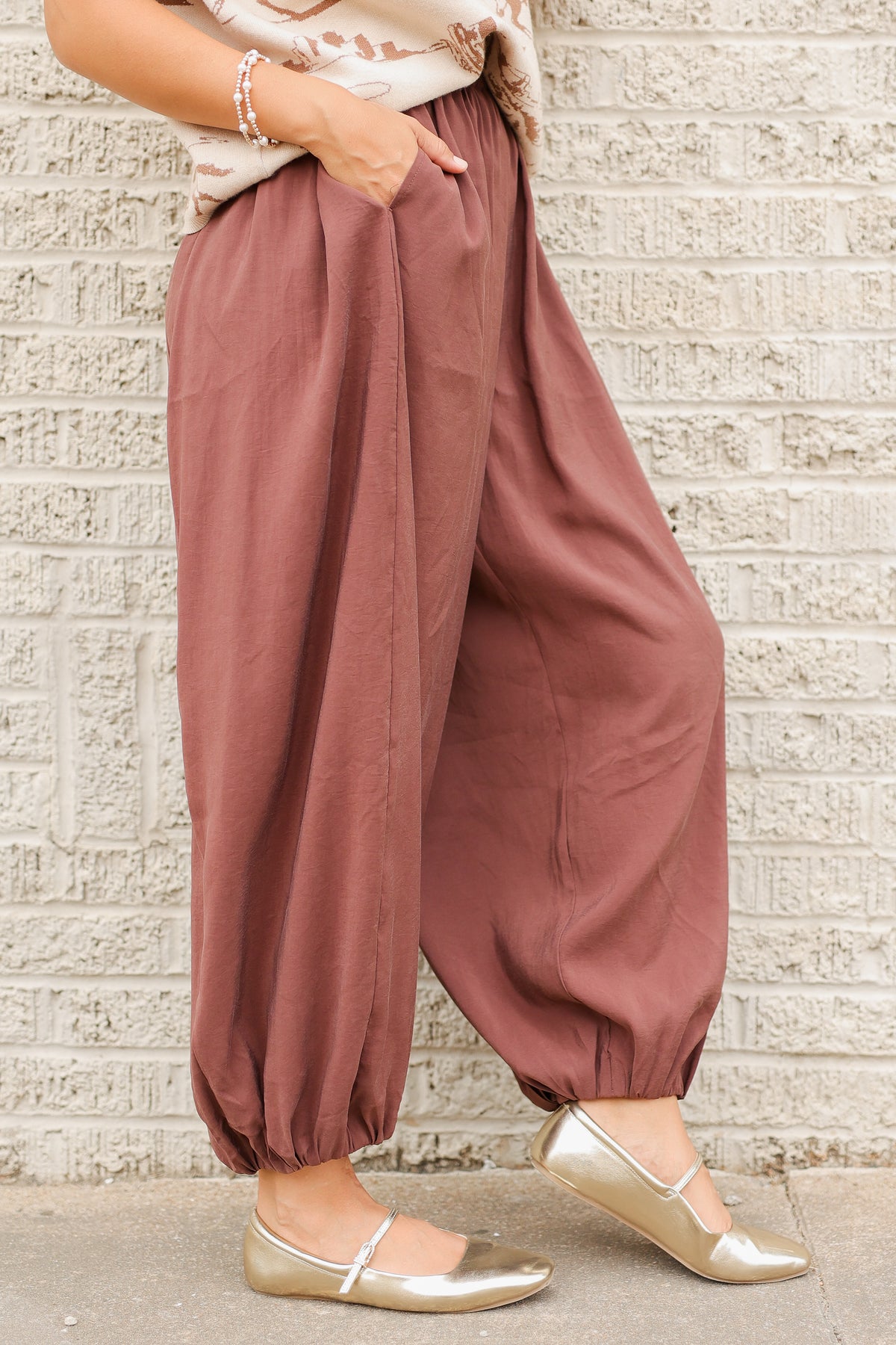 Close-up of Tulara Barrel Pants in Brown featuring a gathered elastic waistband, roomy barrel-leg silhouette, side pockets, and elastic ankle cuffs. Southern House Clothing