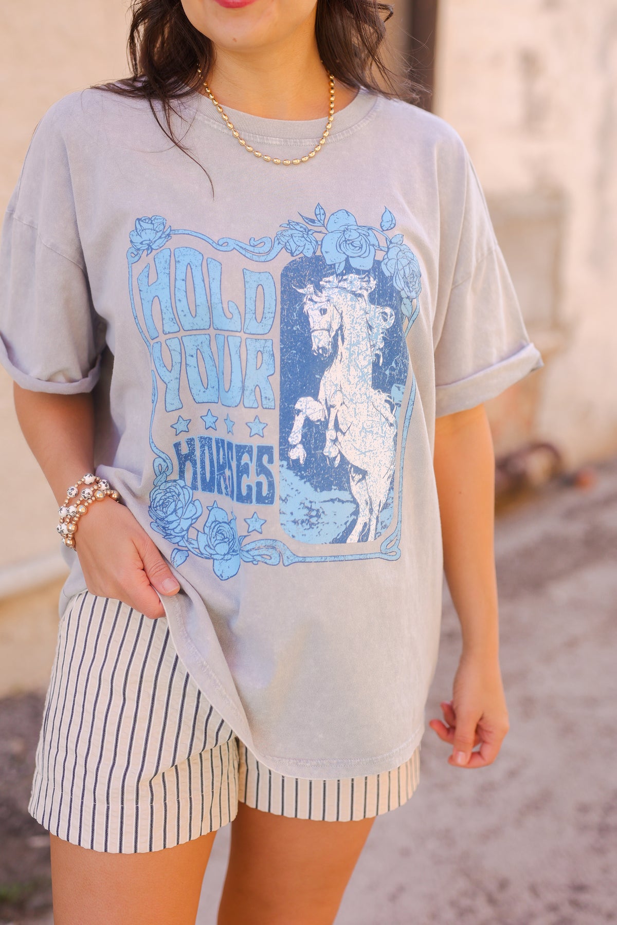 Person wearing a graphic t-shirt with a horse design and text.