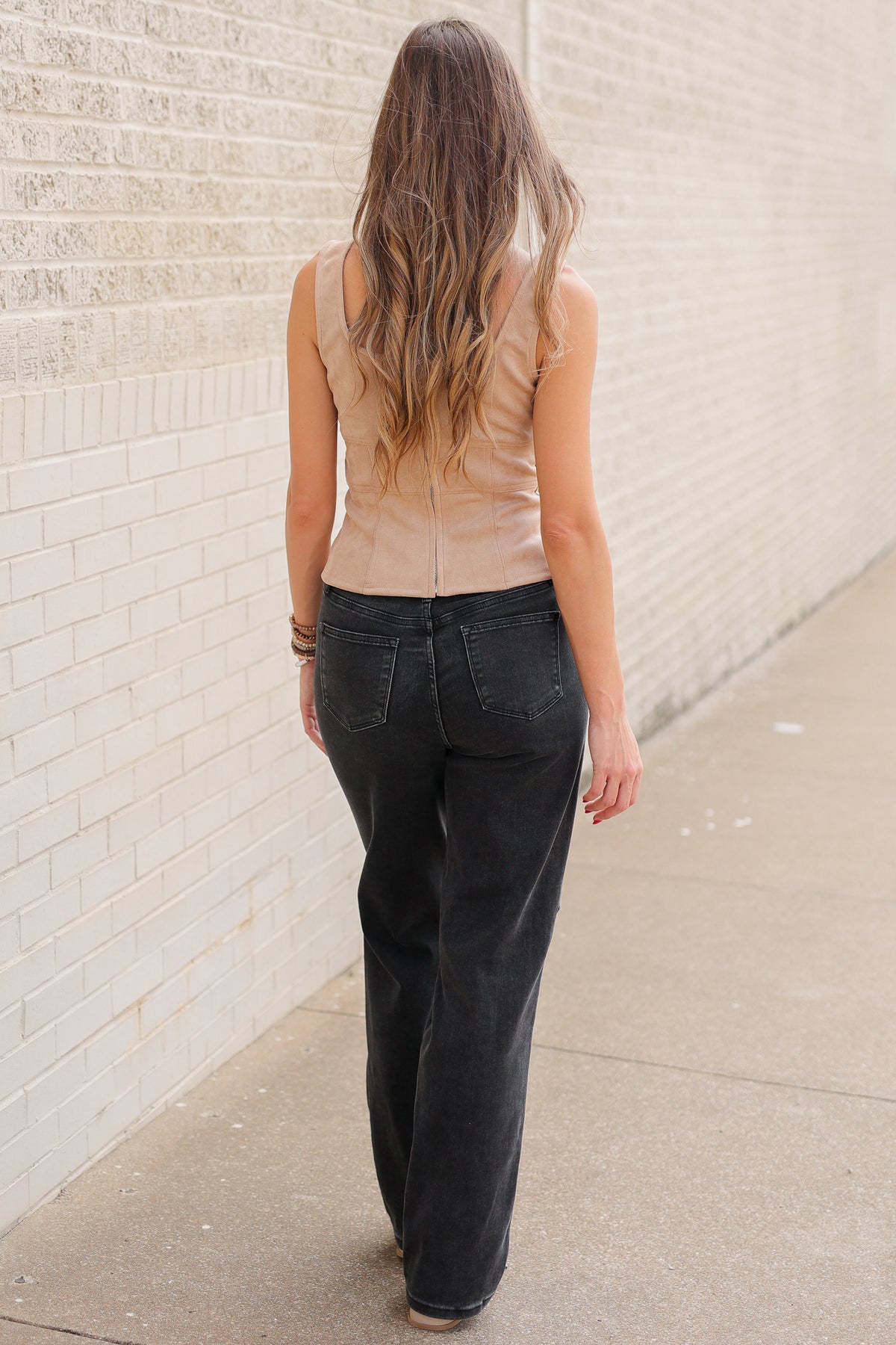 Blonde model wearing Laredo Luxe Studded Fringe Top in Camel featuring silver-tone studs, western fringe, sweetheart neckline, and wide straps, styled with black denim standing outside. Southern House Clothing