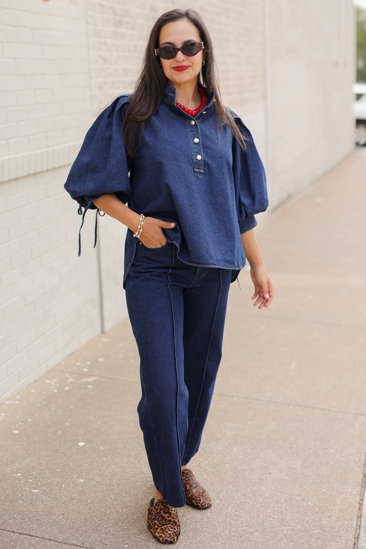 Model wearing the Westhaven Puff Sleeve Denim Top in Dark Wash with Langley Pants and Atlas Leopard Hair Shoes, styled with a red statement necklace. Southern House Clothing