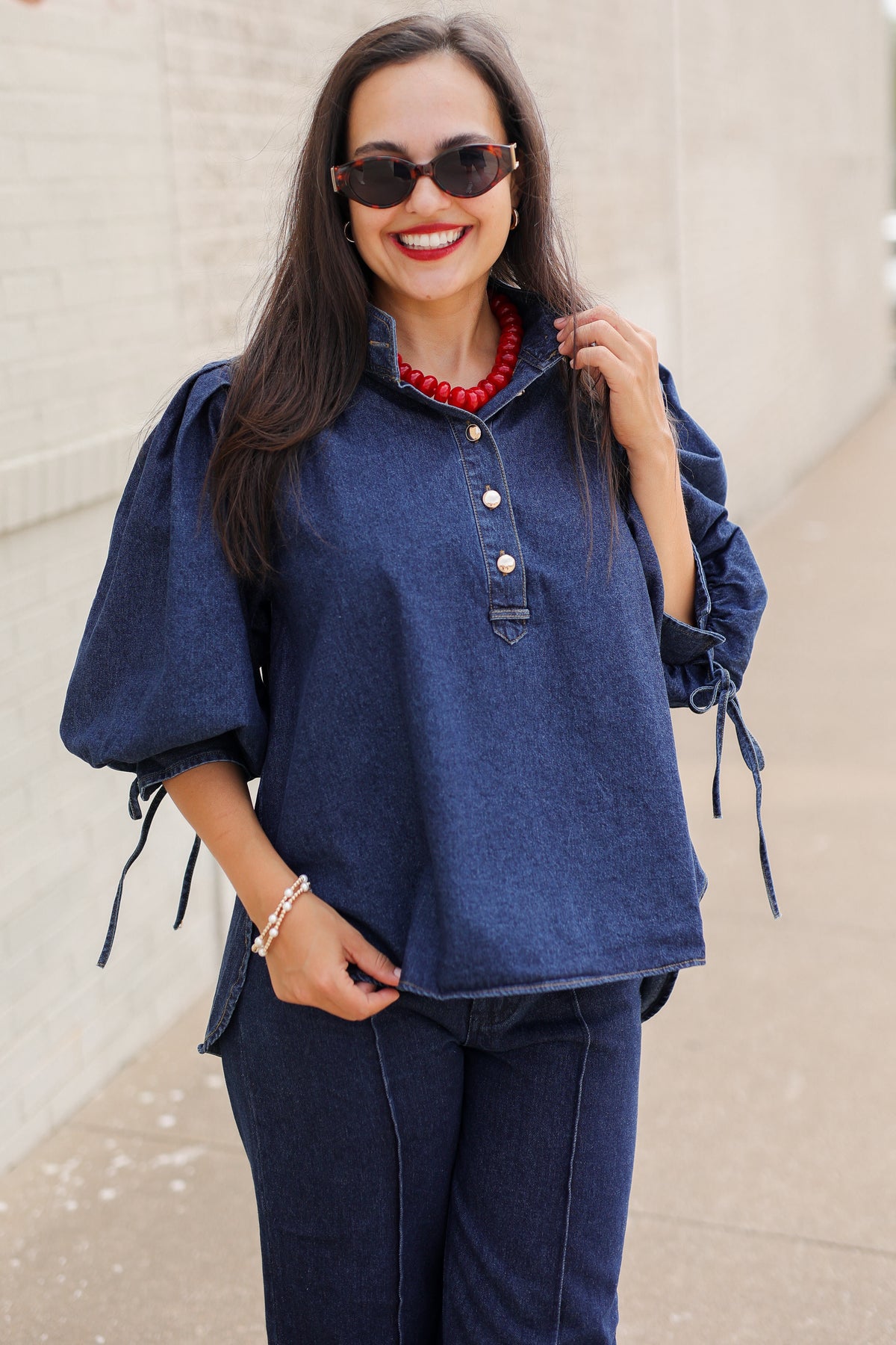 Model wearing the Westhaven Puff Sleeve Denim Top in Dark Wash with Langley Pants and Atlas Leopard Hair Shoes, styled with a red statement necklace. Southern House Clothing