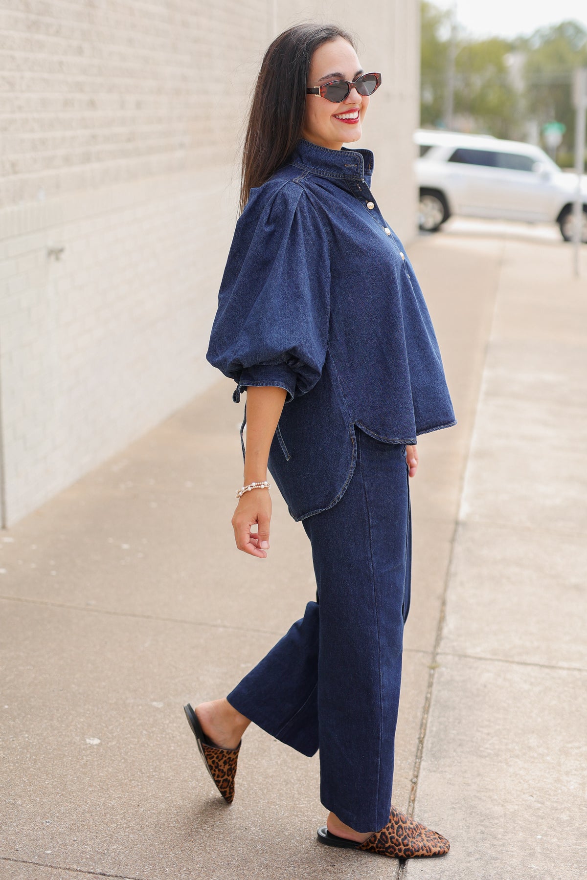 Model wearing the Westhaven Puff Sleeve Denim Top in Dark Wash with Langley Pants and Atlas Leopard Hair Shoes, styled with a red statement necklace. Southern House Clothing