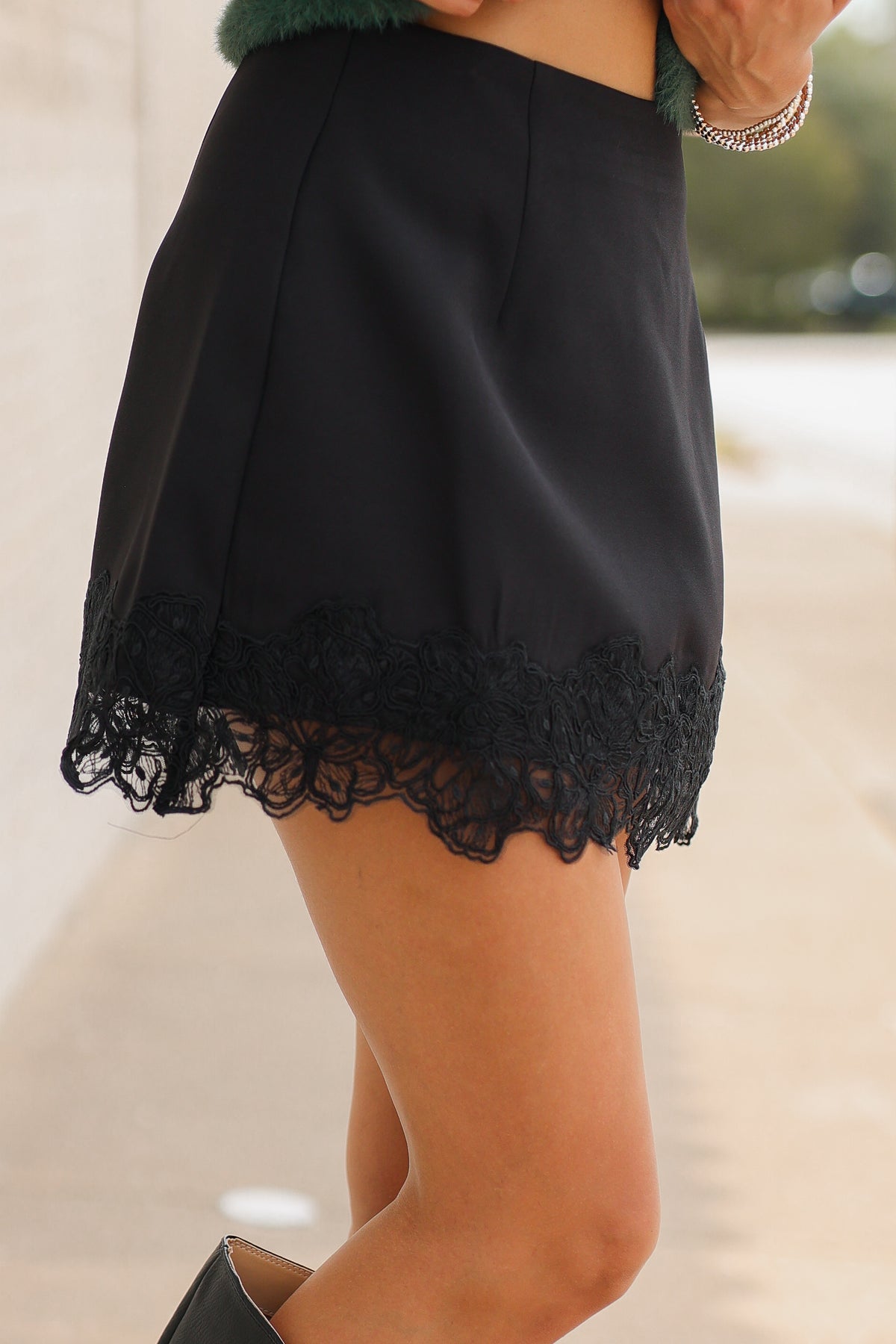 Close up of a model wearing the Bellarose Lace Hem Mini Skort – Black. Southern House Clothing