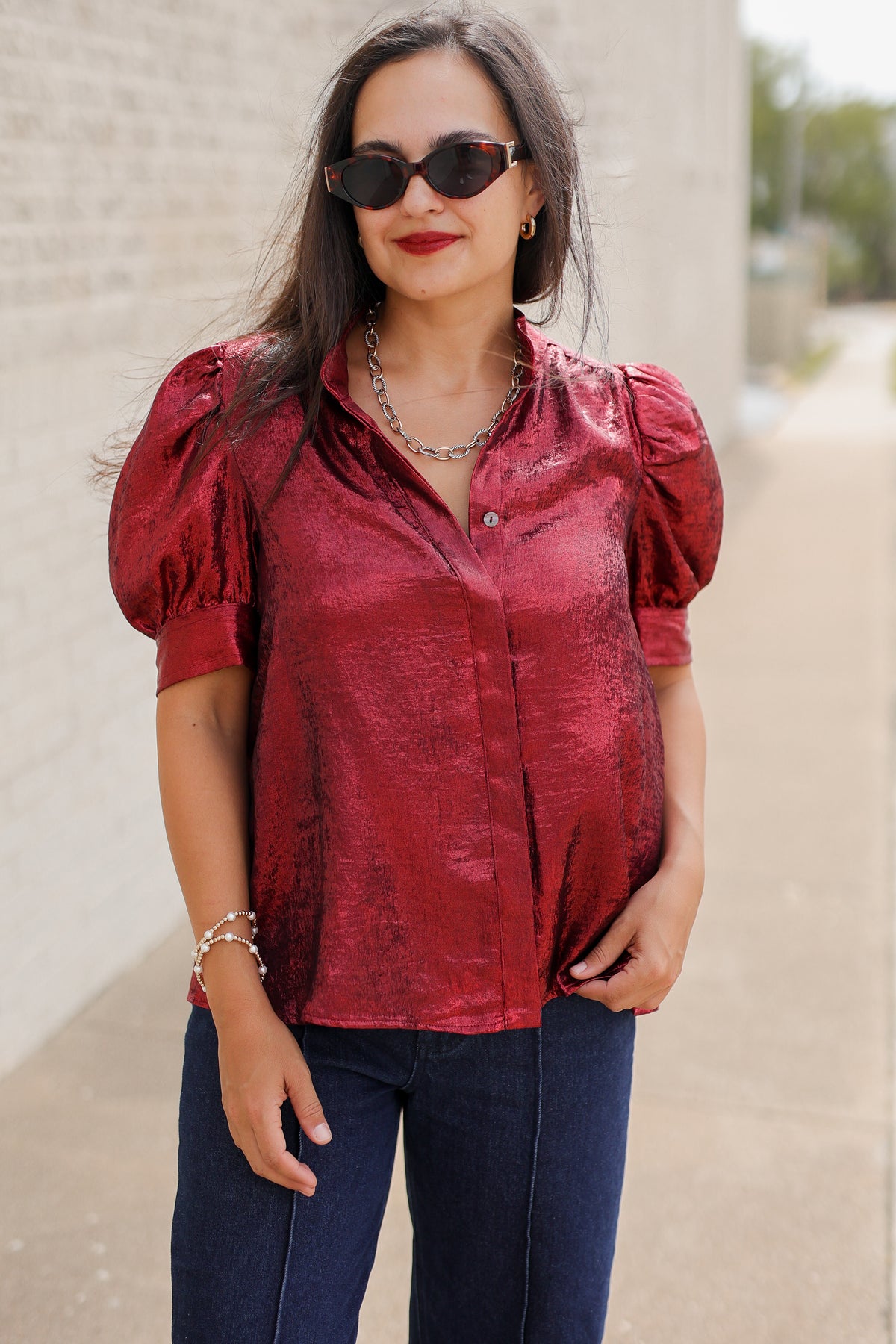Model wearing the Bellmont Satin Puff Sleeve Blouse in Burgundy with dark-wash wide-leg jeans called the Langley, leopard-print flats called the Atlus, and silver jewelry for a chic casual outfit. Southern House Clothing