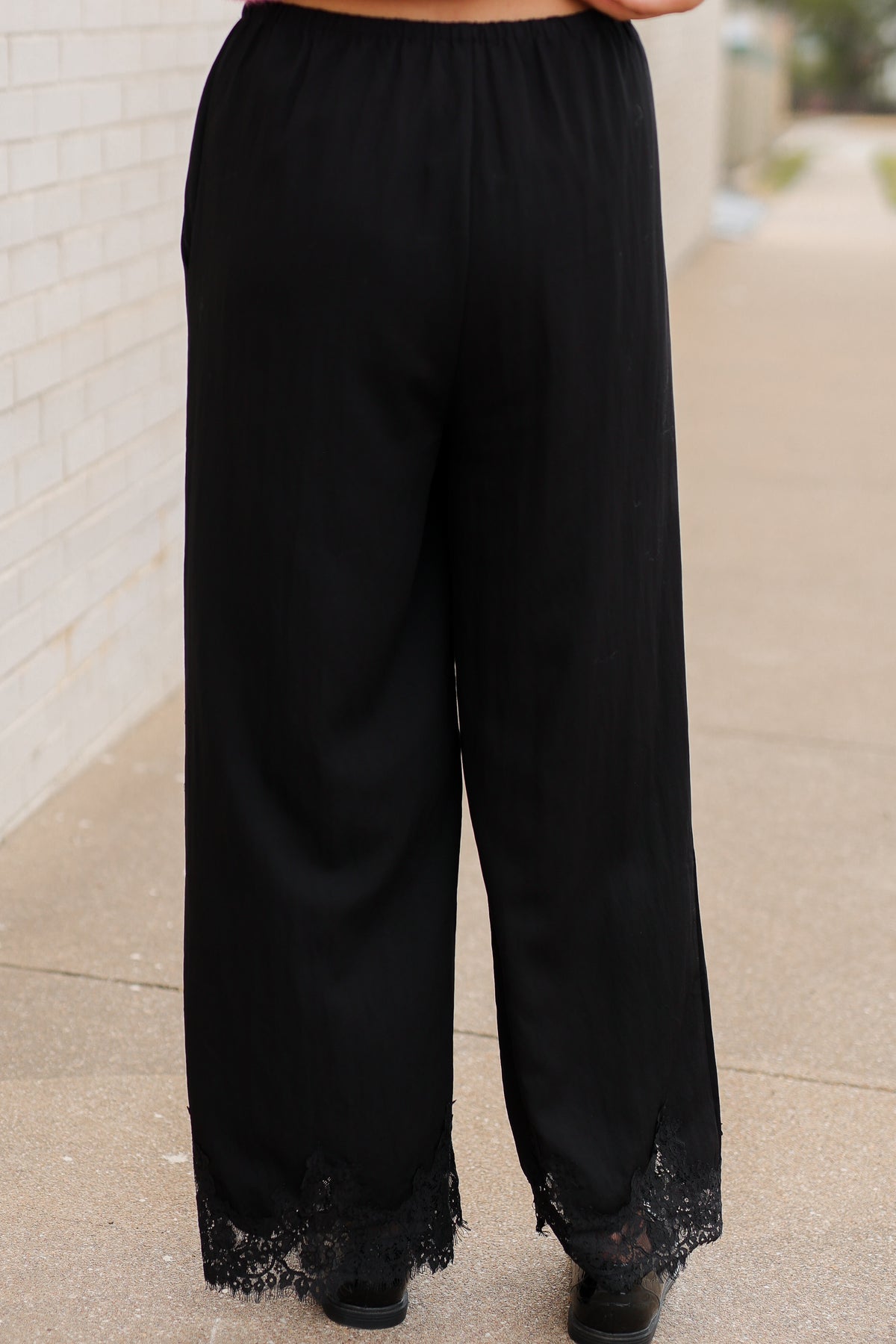 Close up of a black laced pants on a model outside. Southern House Clothing