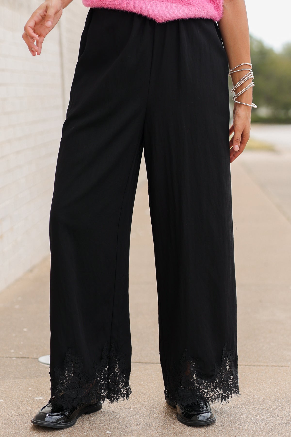 Close up of black laced pants on a model standing outside. Southern House Clothing