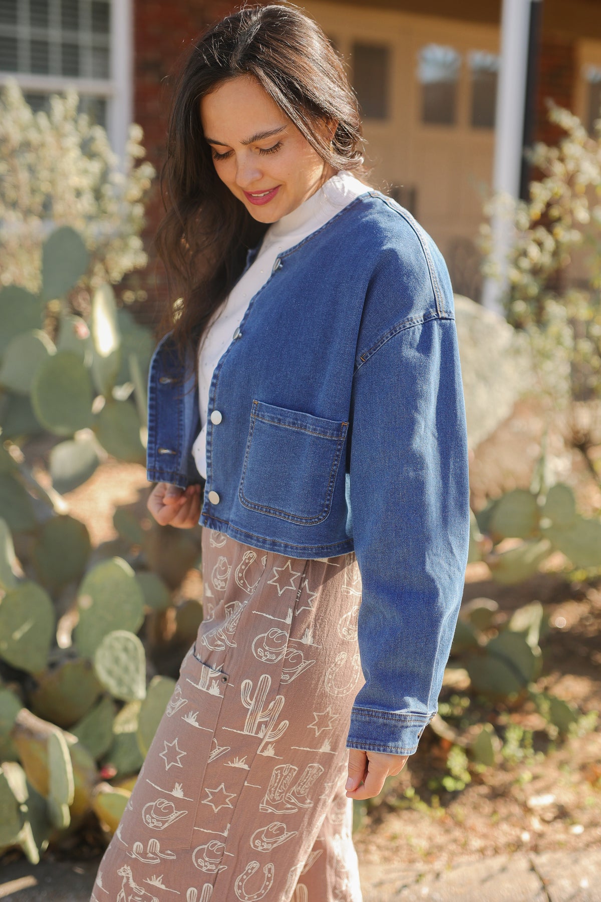 Woman wearing a blue denim jacket in front of cacti
