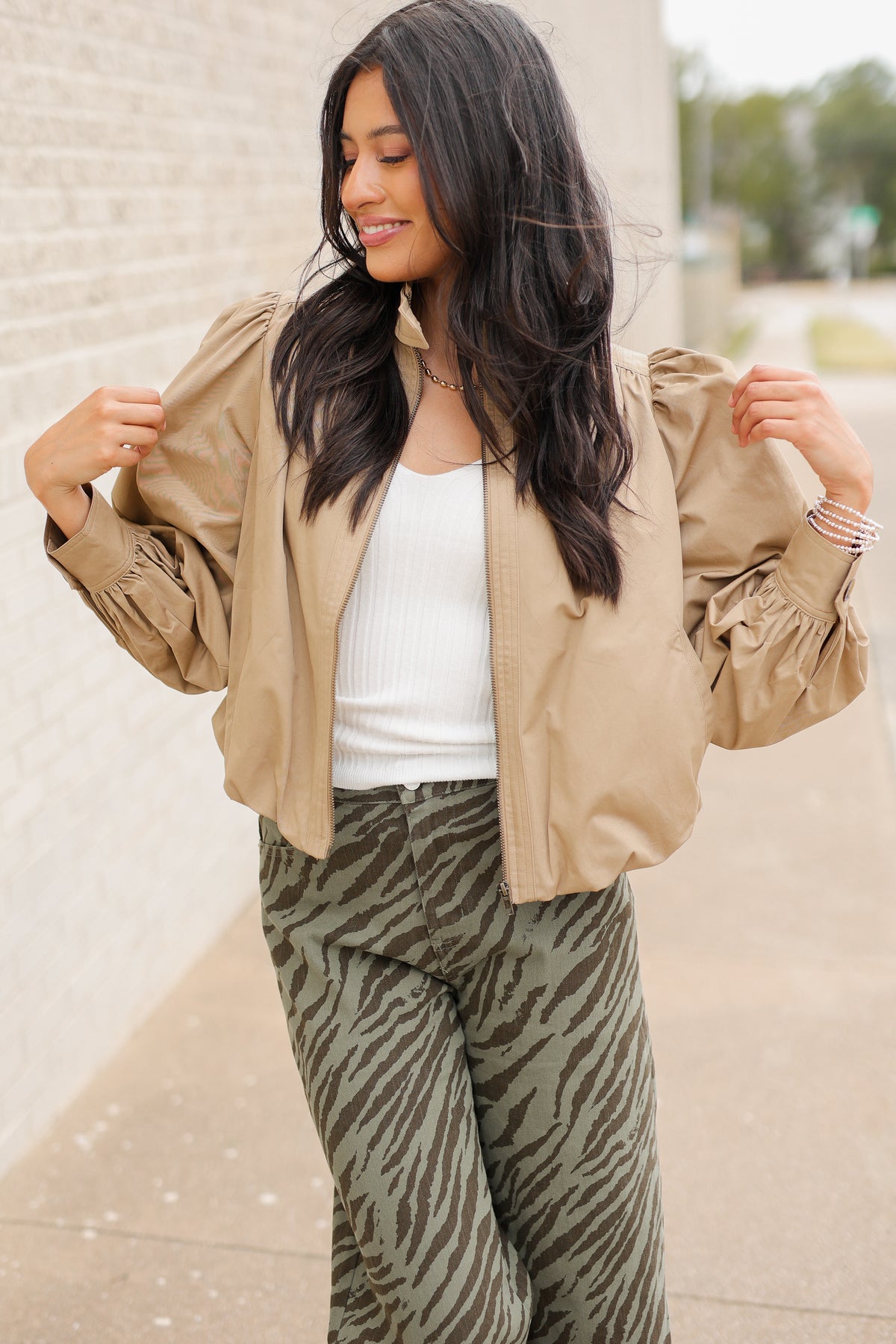 Winscott Puff Sleeve Zip Jacket in Khaki styled with Safari Stroll Wide Leg Pants in olive animal print and metallic gold ballet flats, showing the cropped fit and puff sleeves. Southern House Clothing