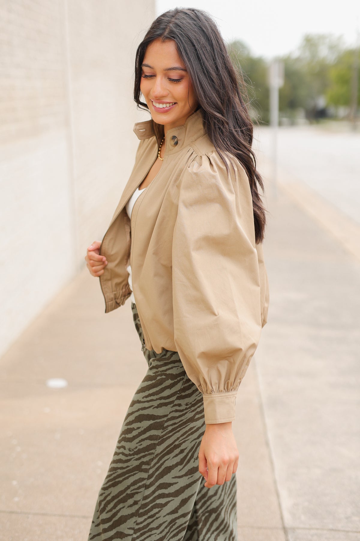 Winscott Puff Sleeve Zip Jacket in Khaki styled with Safari Stroll Wide Leg Pants in olive animal print and metallic gold ballet flats, showing the cropped fit and puff sleeves. Southern House Clothing