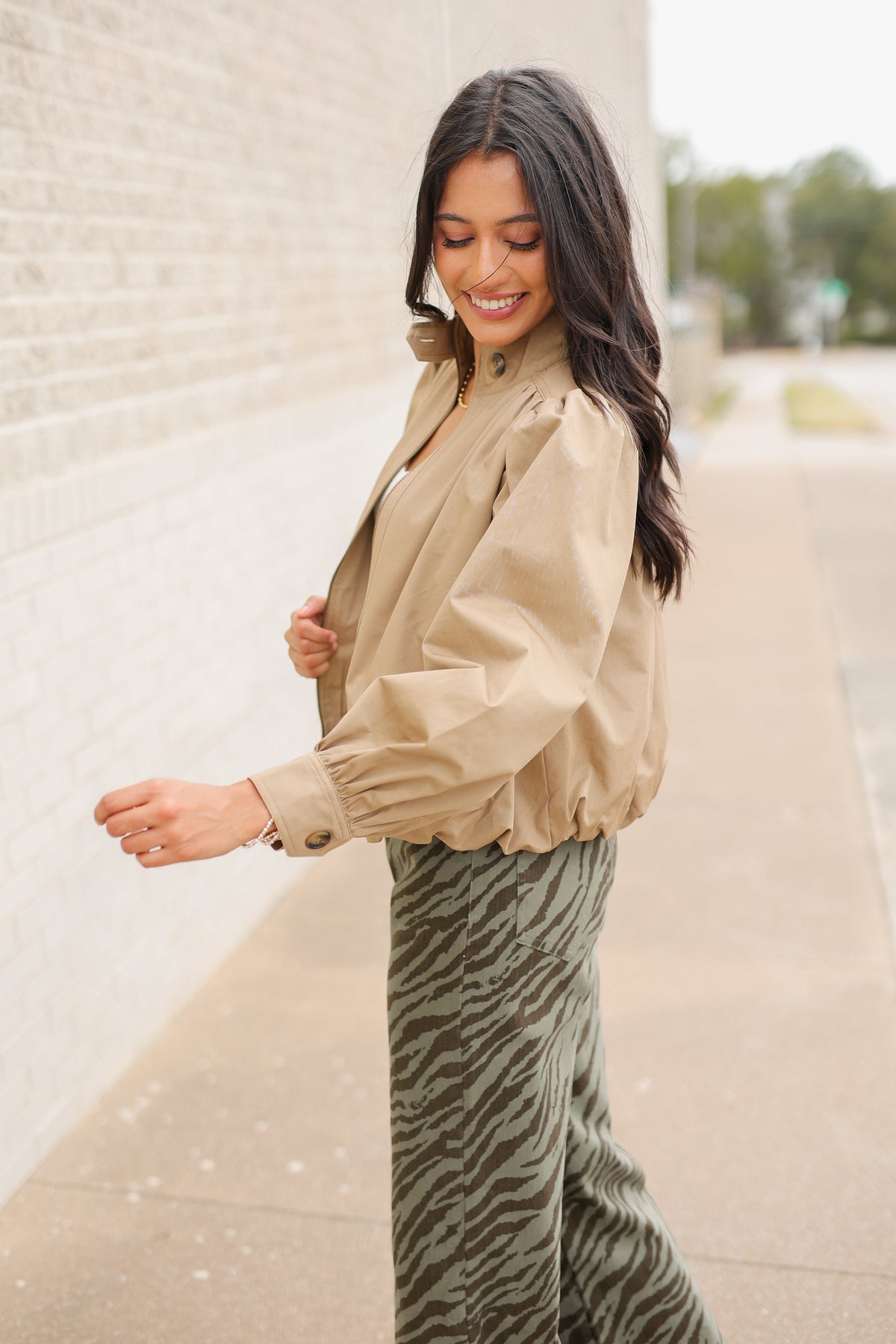 Winscott Puff Sleeve Zip Jacket in Khaki styled with Safari Stroll Wide Leg Pants in olive animal print and metallic gold ballet flats, showing the cropped fit and puff sleeves. Southern House Clothing