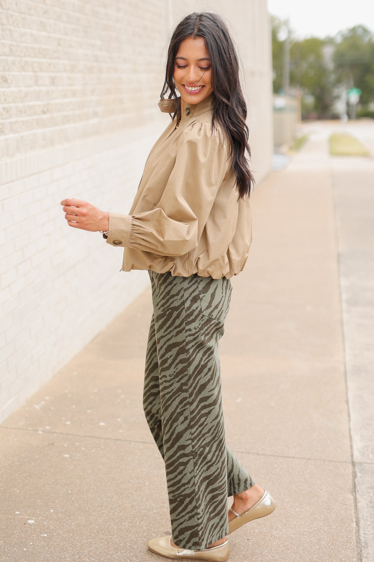Winscott Puff Sleeve Zip Jacket in Khaki styled with Safari Stroll Wide Leg Pants in olive animal print and metallic gold ballet flats, showing the cropped fit and puff sleeves. Southern House Clothing