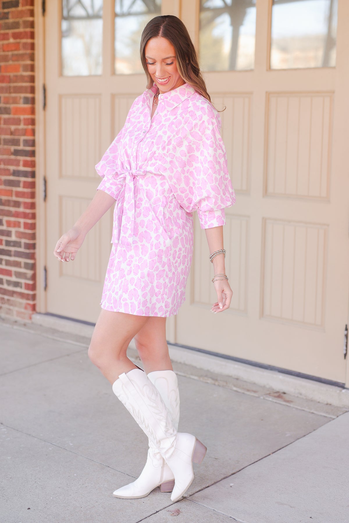 Woman wearing a pink leopard print dress outside.