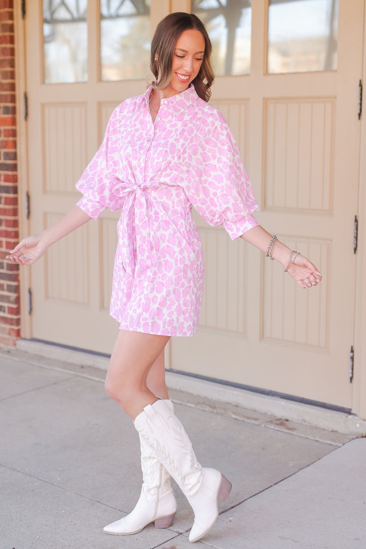 Woman wearing a pink leopard print dress outside.