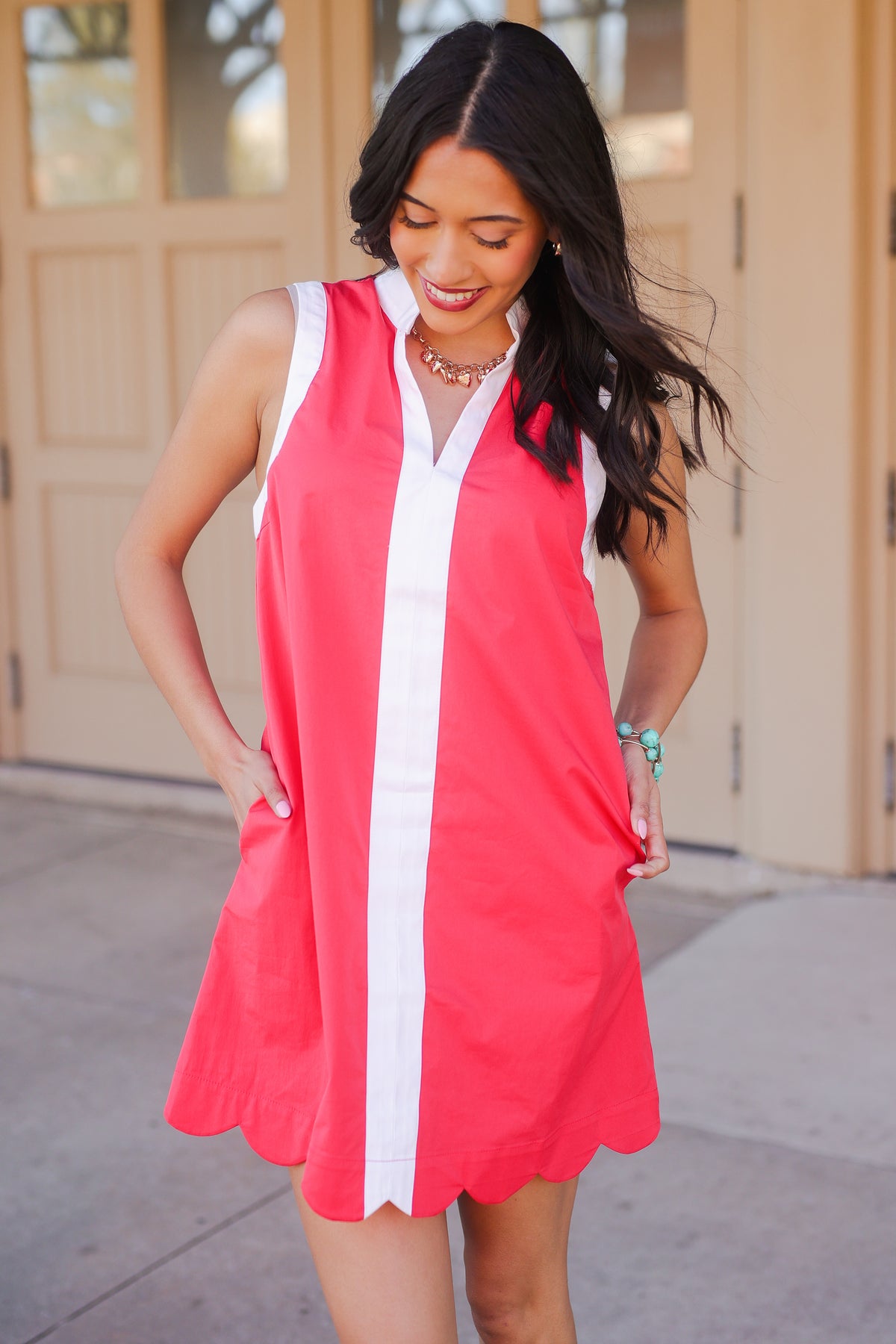 Woman wearing a red and white dress standing outdoors.