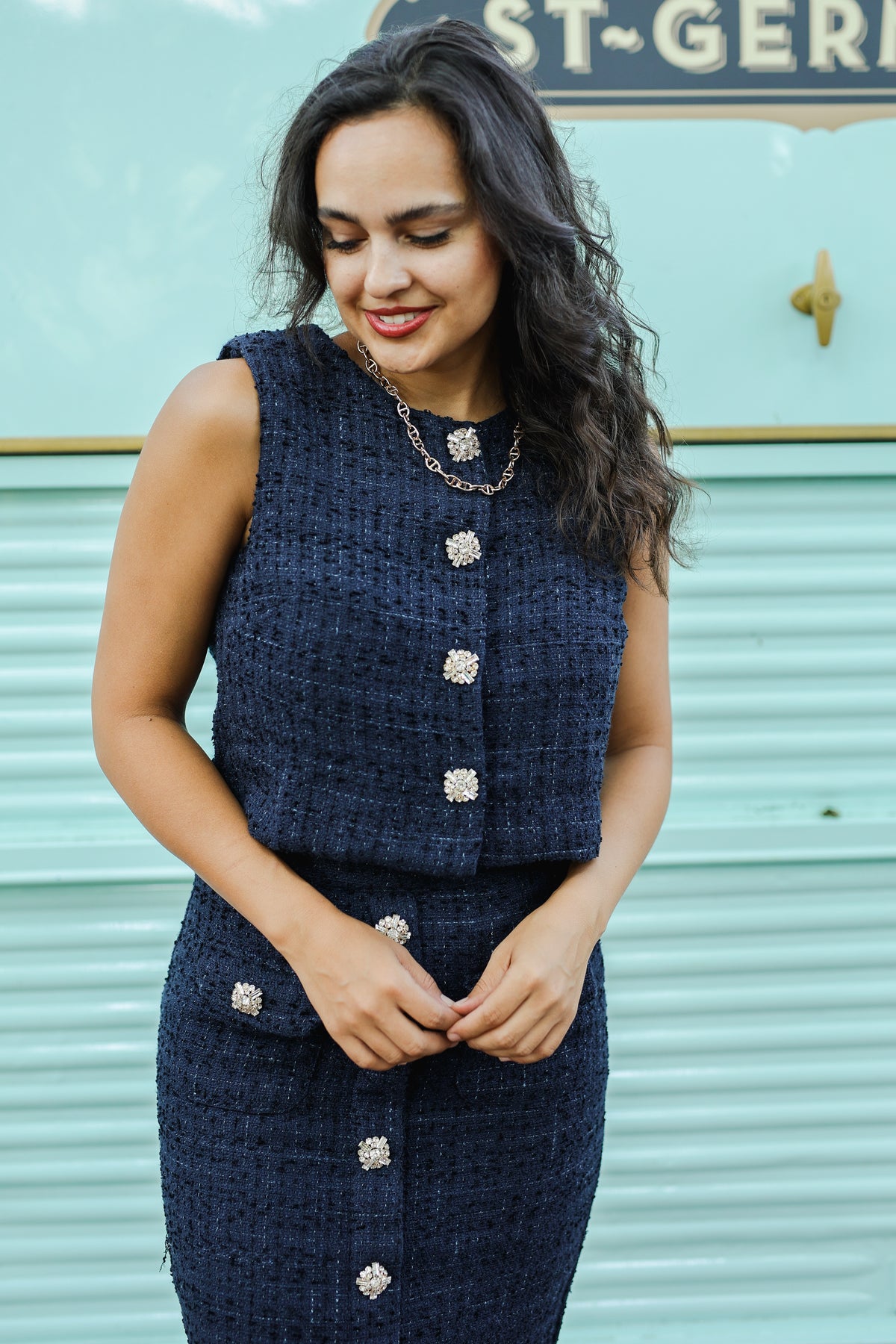 Woman wearing a navy blue tweed dress with silver buttons against a light blue background | Southern House Clothing 
