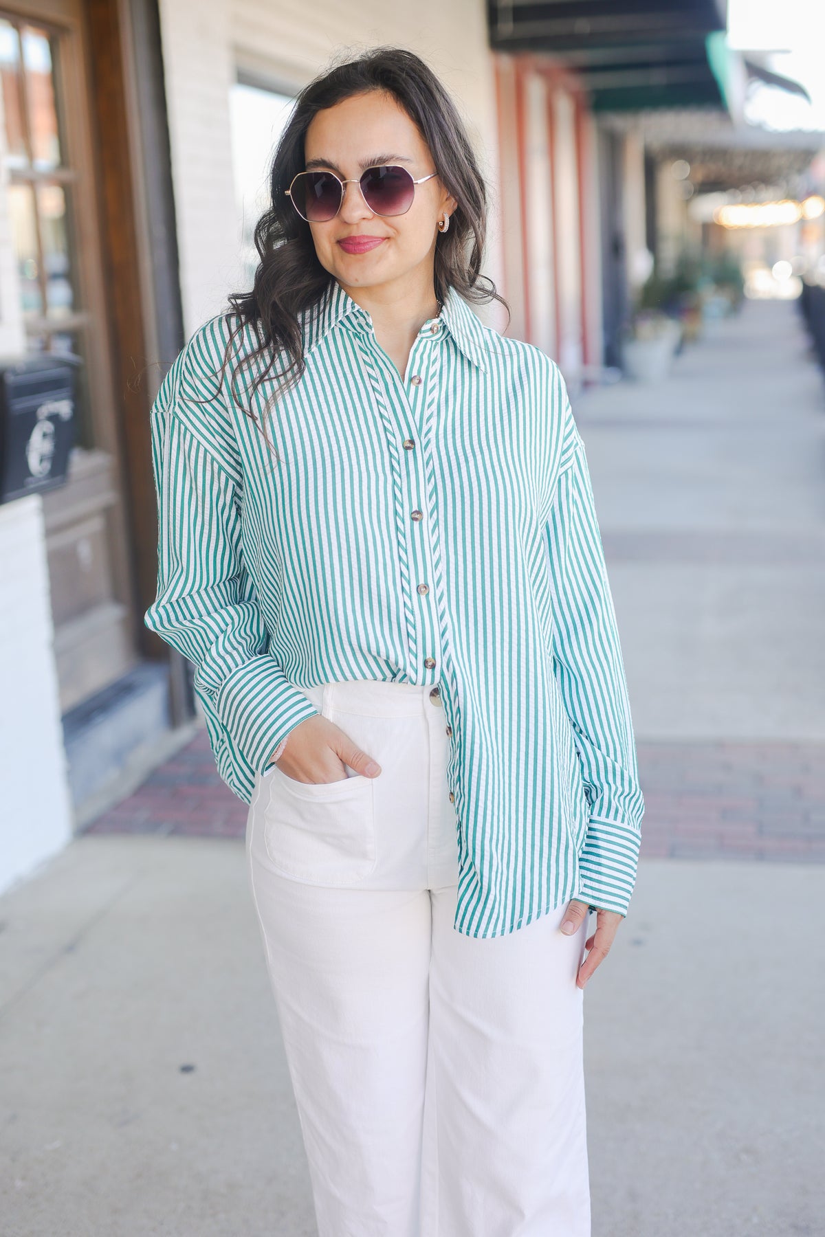 Woman wearing a green and white striped shirt and white pants on a city street. - The Carolina Coast Stripe Button Down - Green