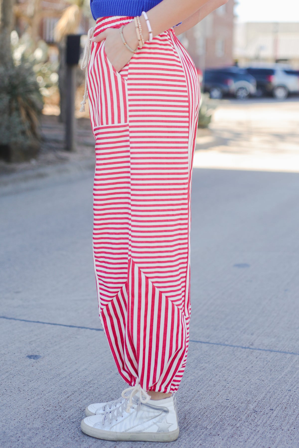Person wearing red and white striped pants on a street.