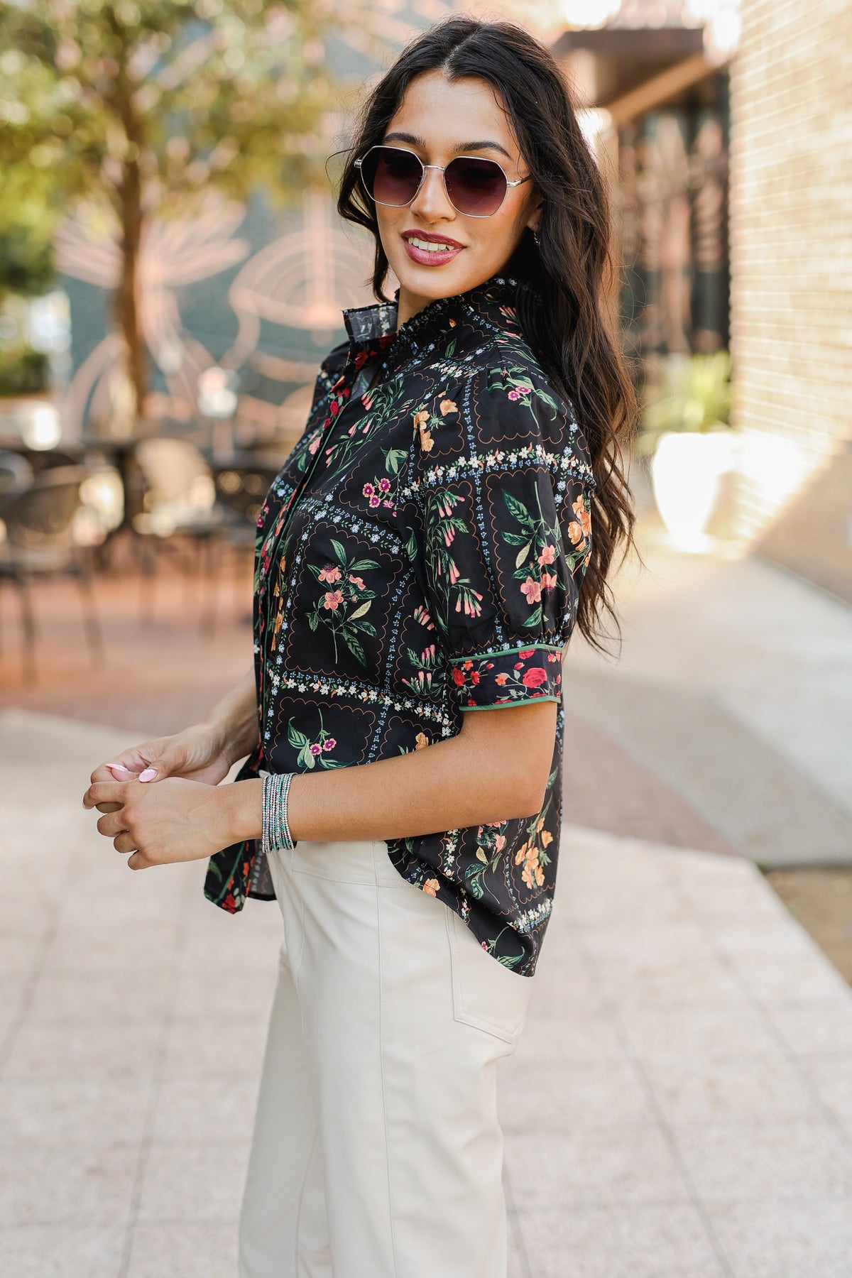 Woman wearing a floral shirt and sunglasses outdoors