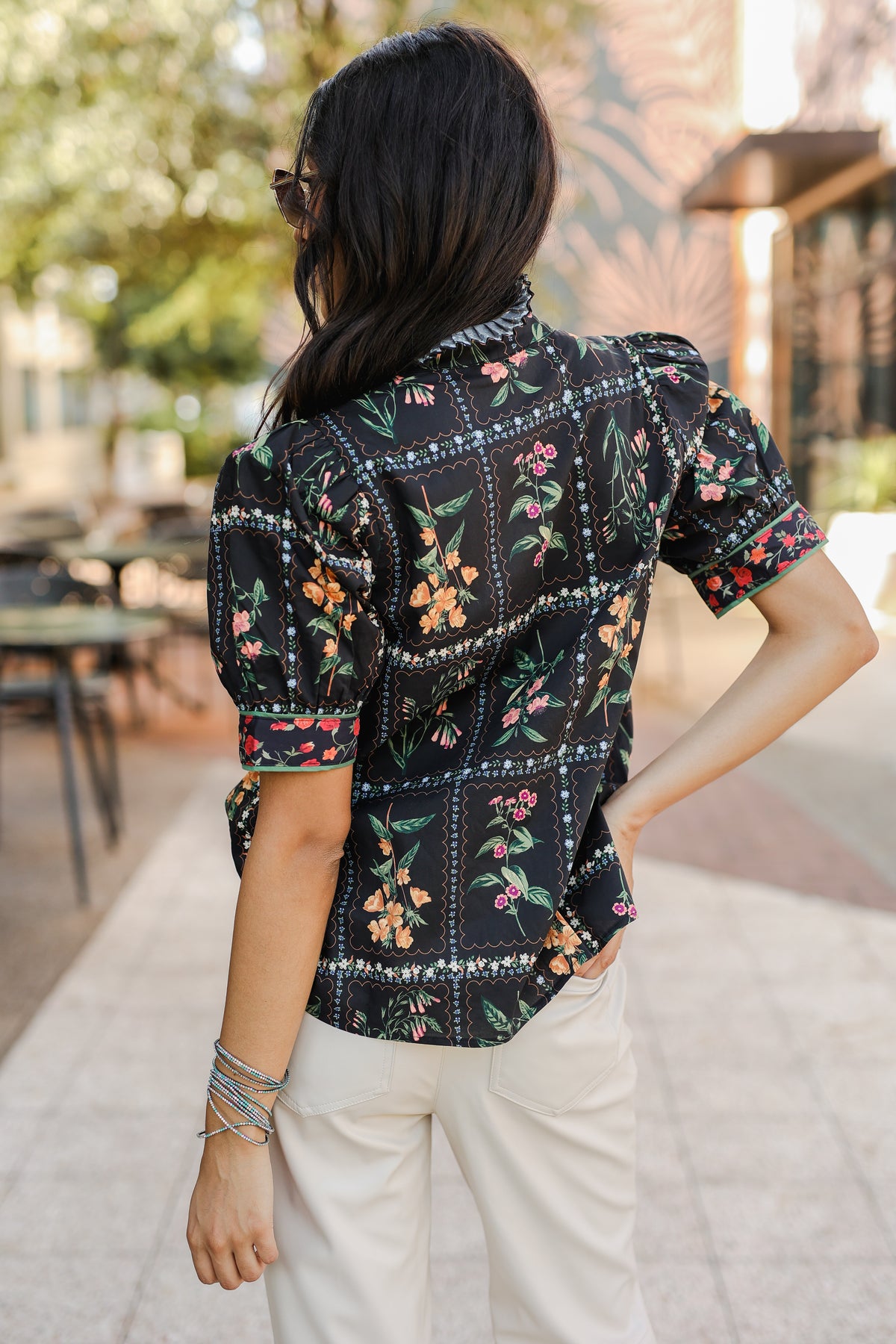 Person wearing a floral patterned shirt outdoors