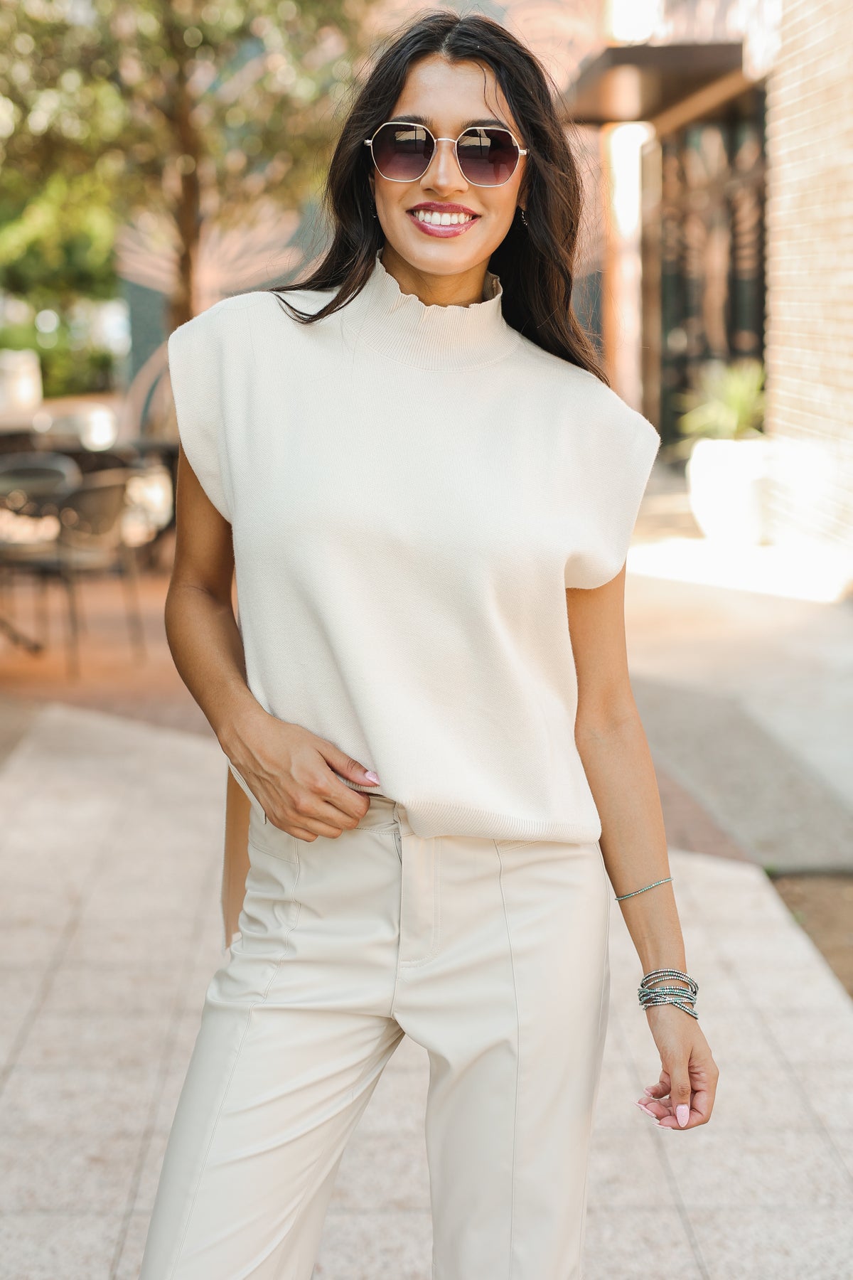 Woman wearing a white outfit with sunglasses outdoors