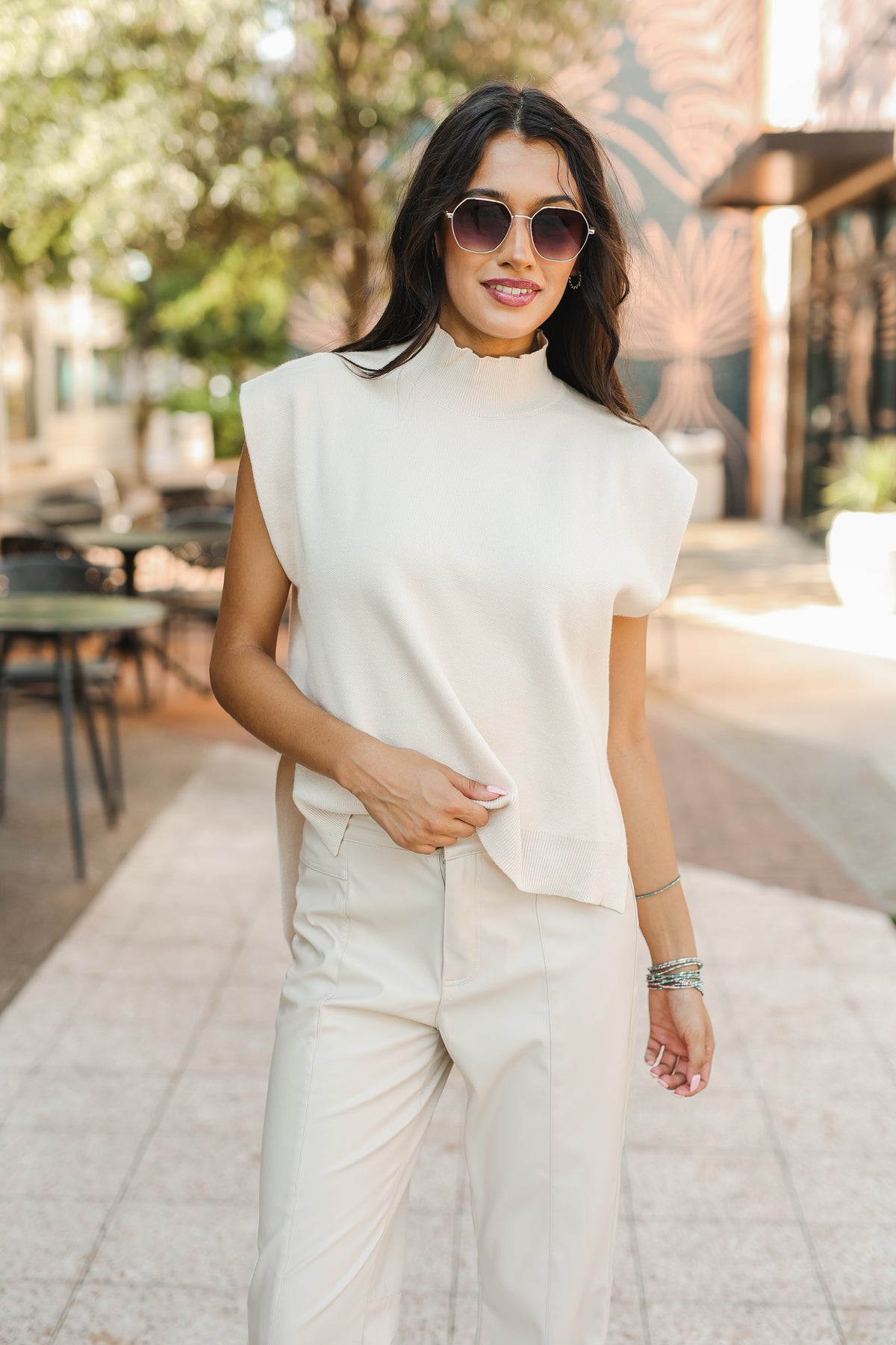 Woman wearing a white outfit with sunglasses outdoors