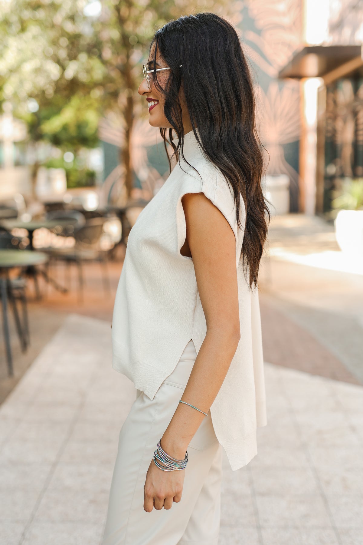 Woman in a white dress standing outdoors with blurred background