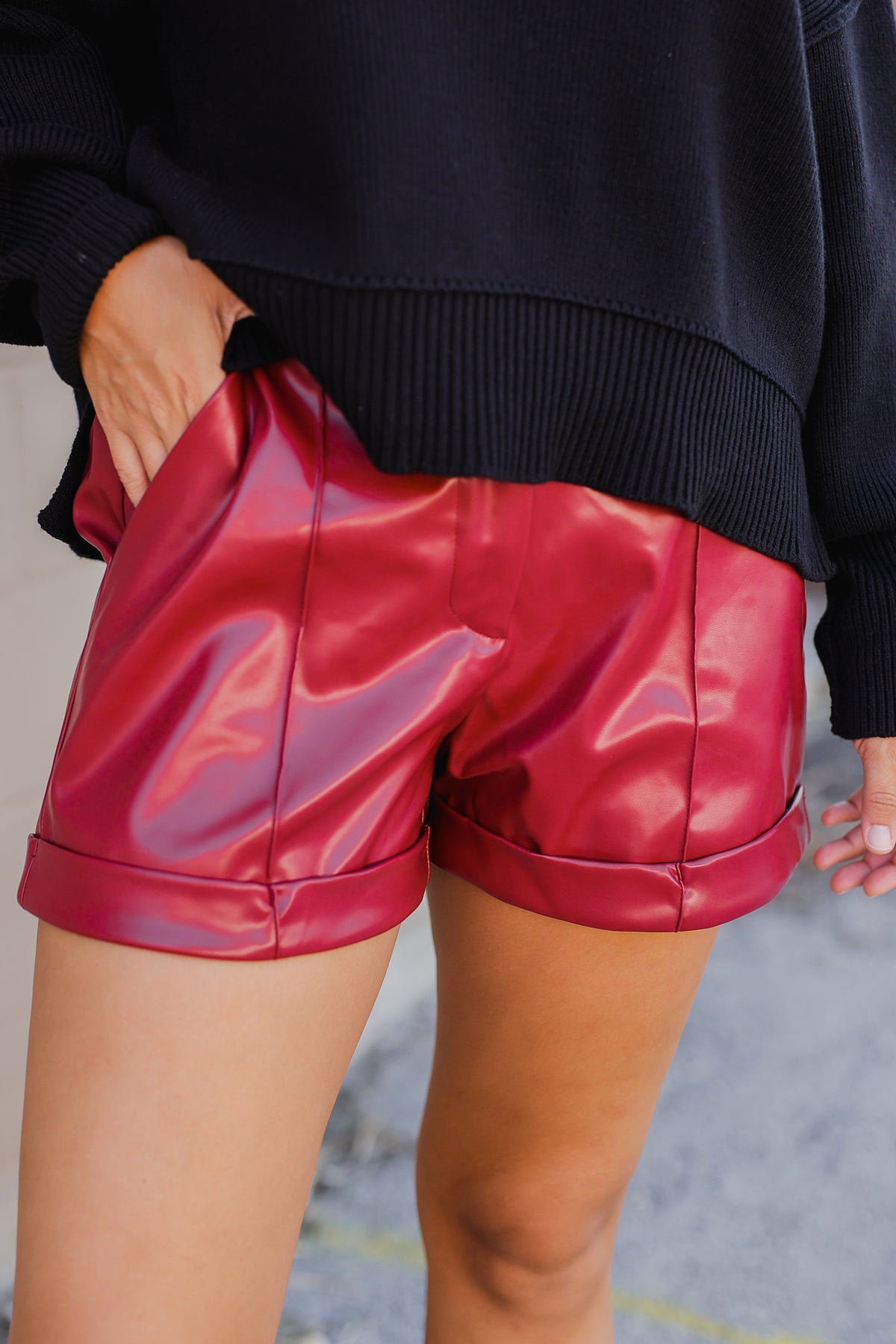 Person wearing red shiny shorts with a blurred background