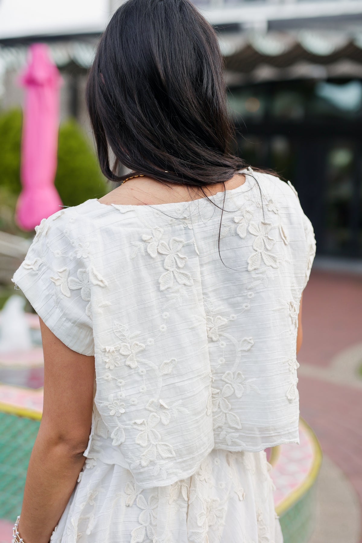 Woman wearing a white floral dress with a blurred background