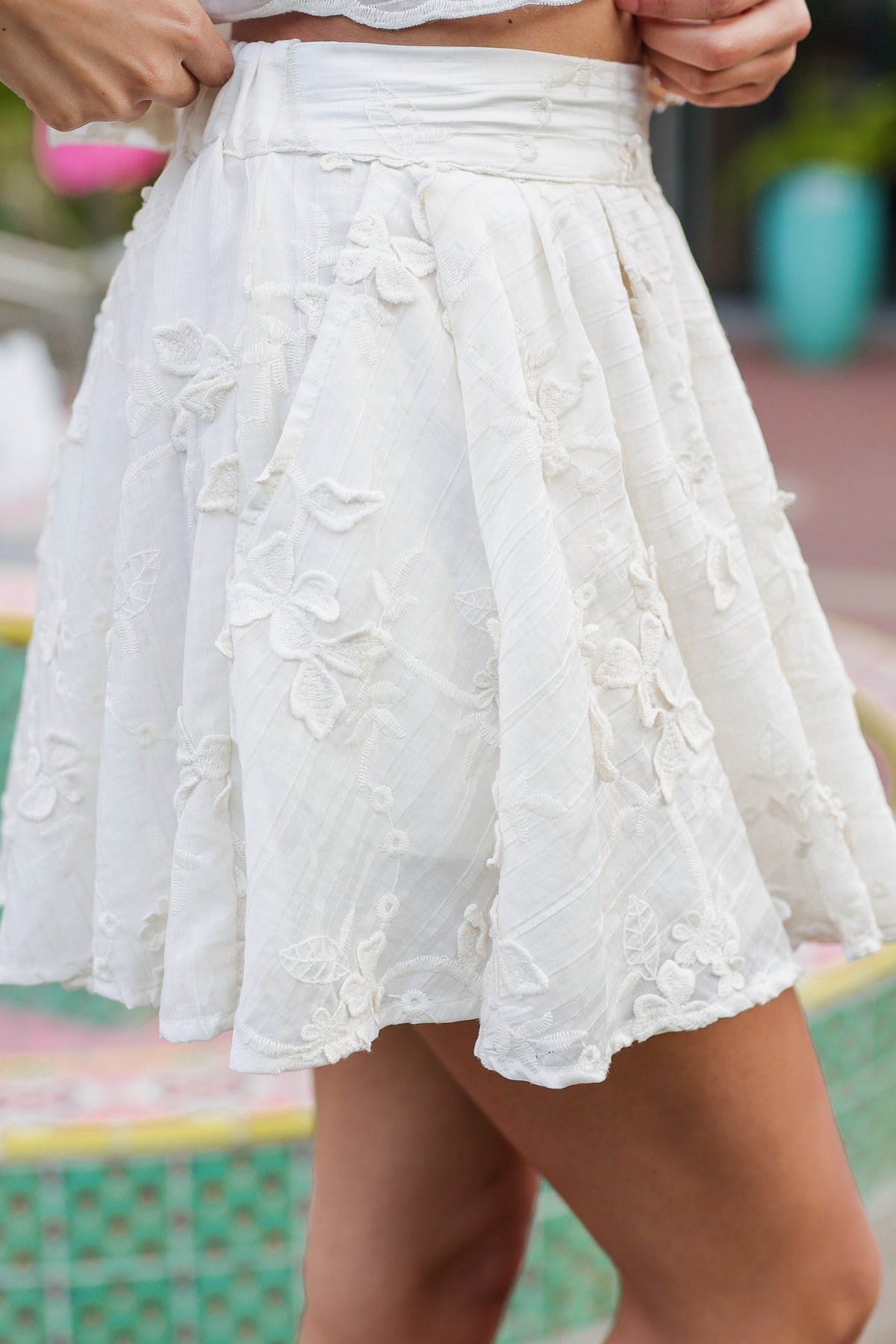 White lace skirt worn by a person with a blurred background