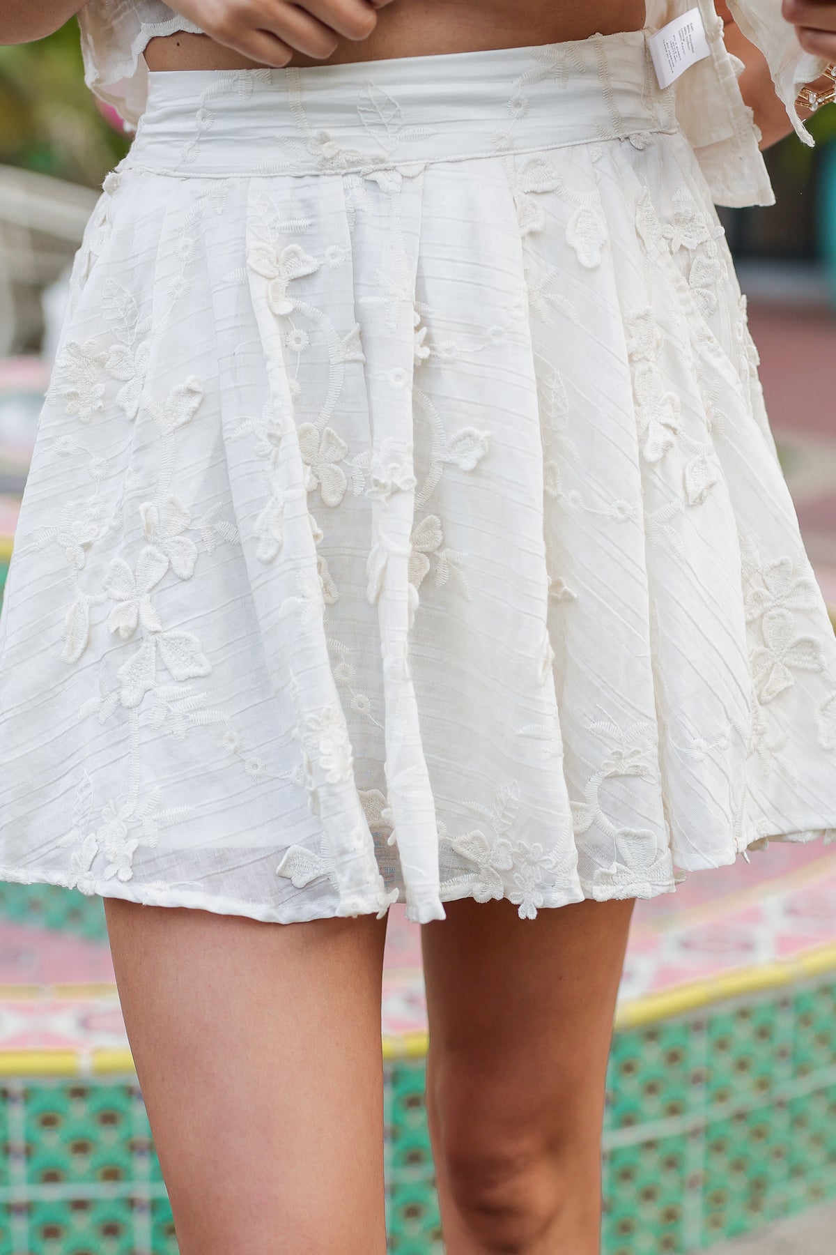 White lace skirt worn by a person with a blurred background