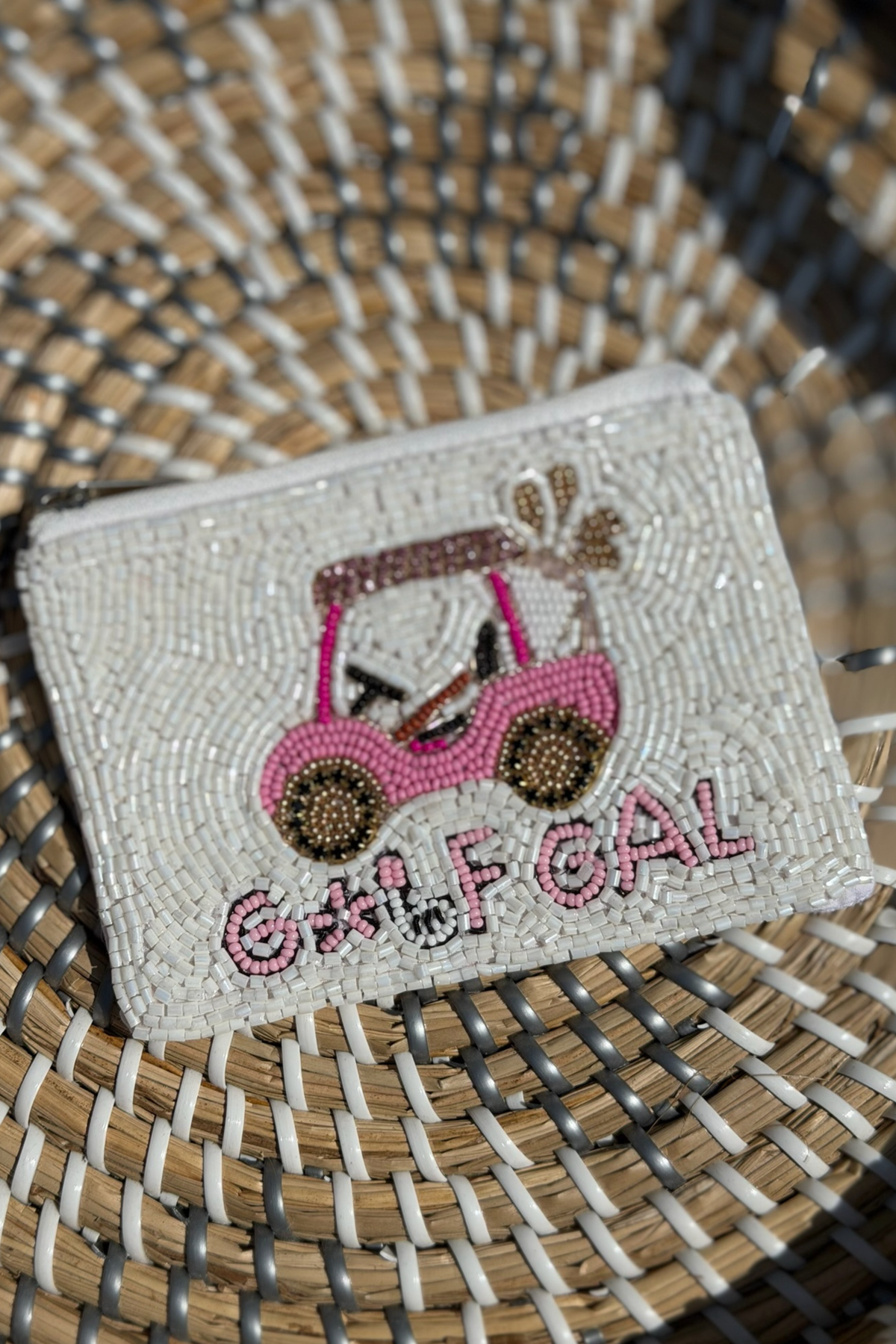 Beaded pouch with pink sunglasses and 'Golf Gal' text on a woven surface