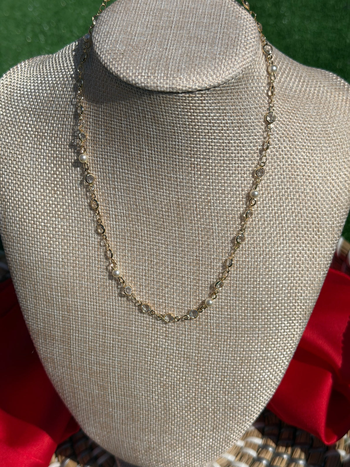 Necklace on a mannequin bust with a red fabric background