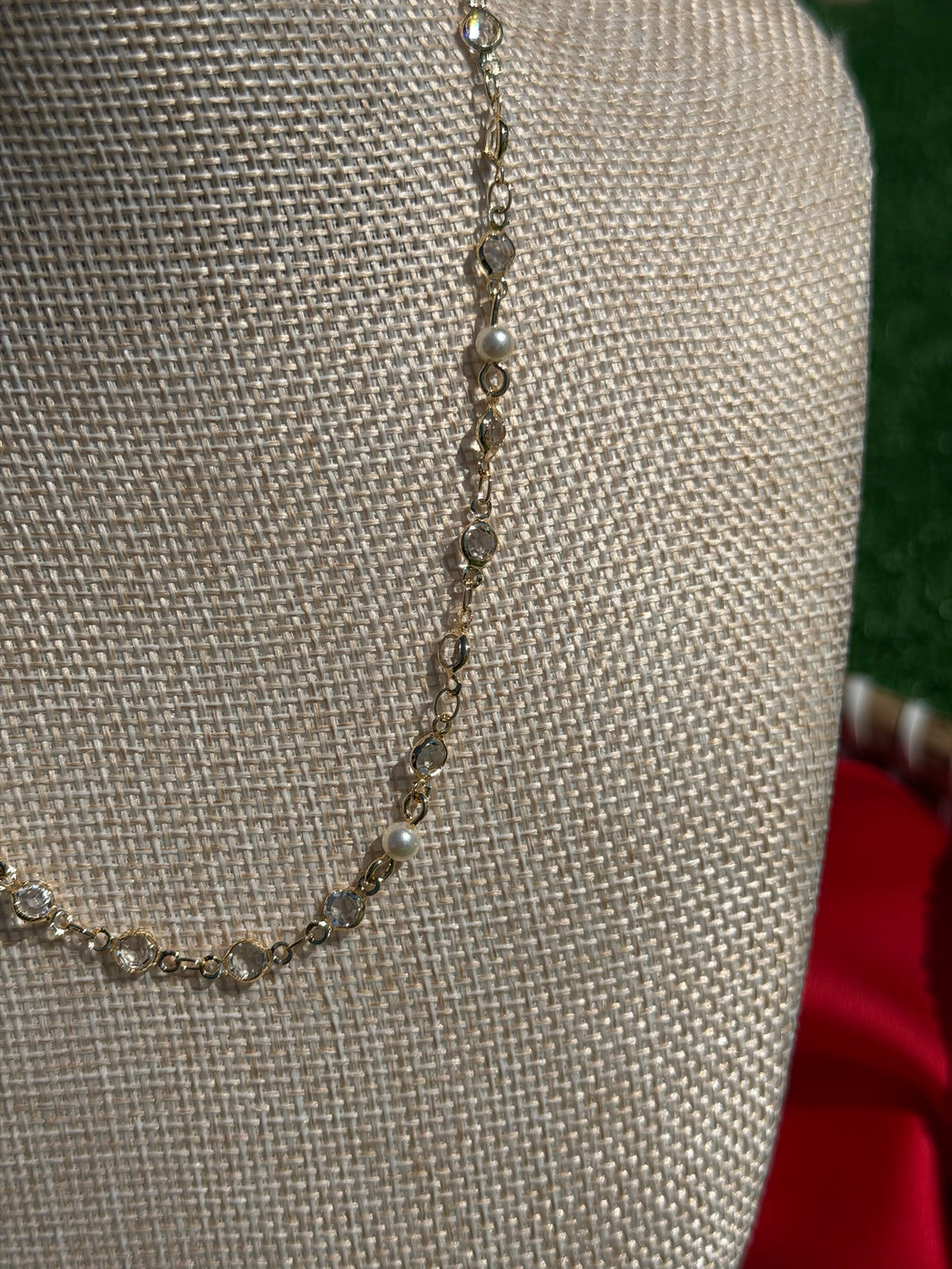 Delicate silver bracelet on a mannequin bust with a red fabric background