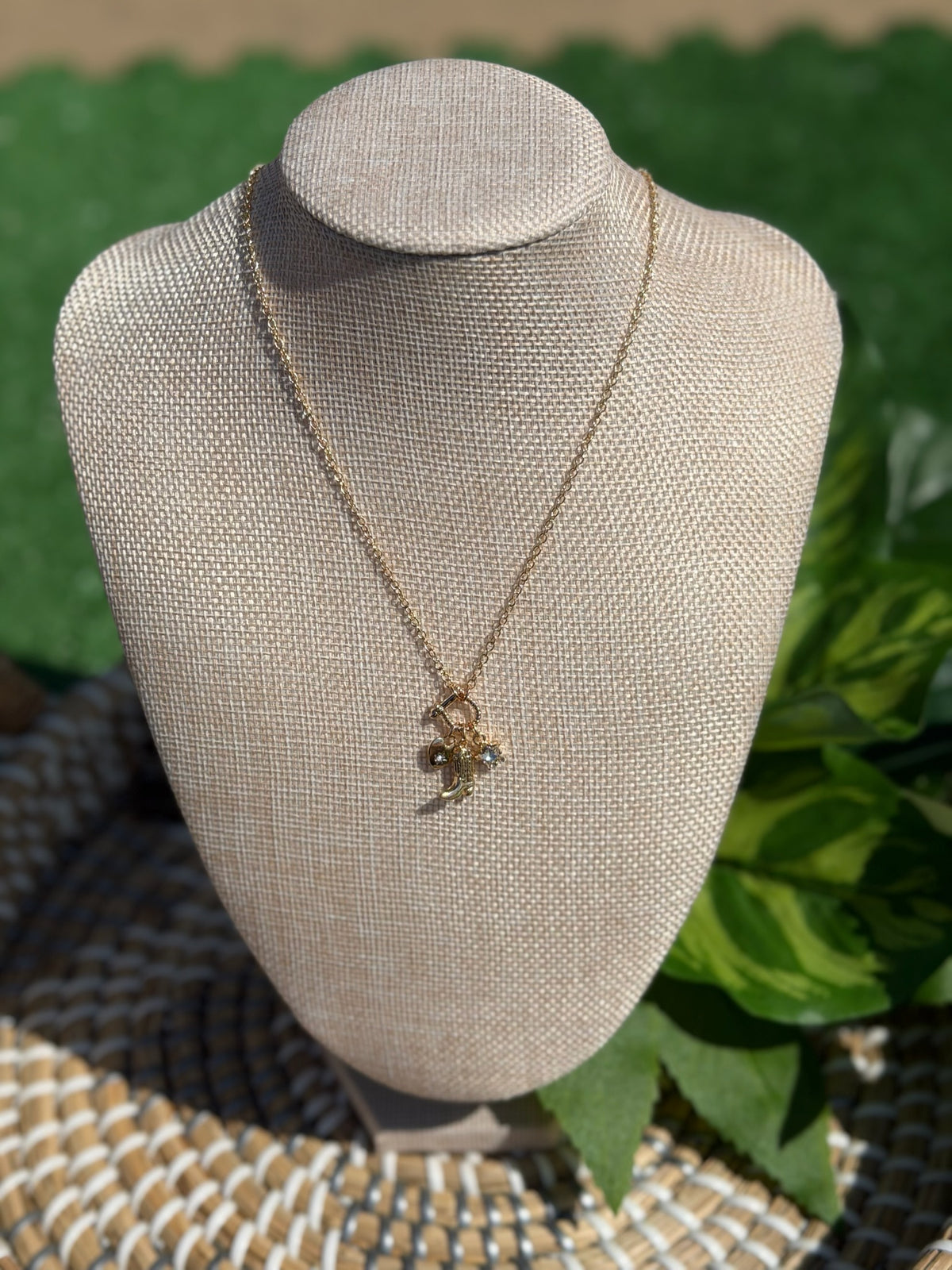 Necklace with a pendant on a mannequin bust against a green leafy background