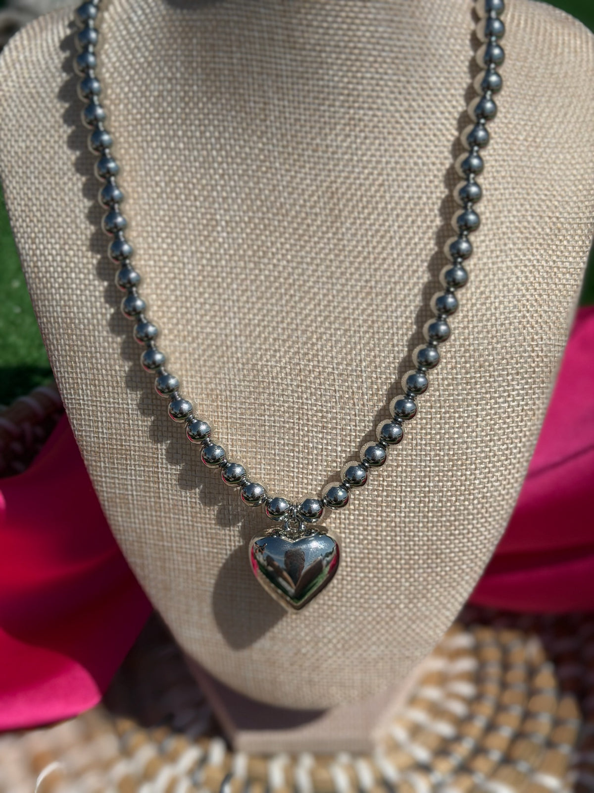 Necklace with a heart pendant on a mannequin bust.