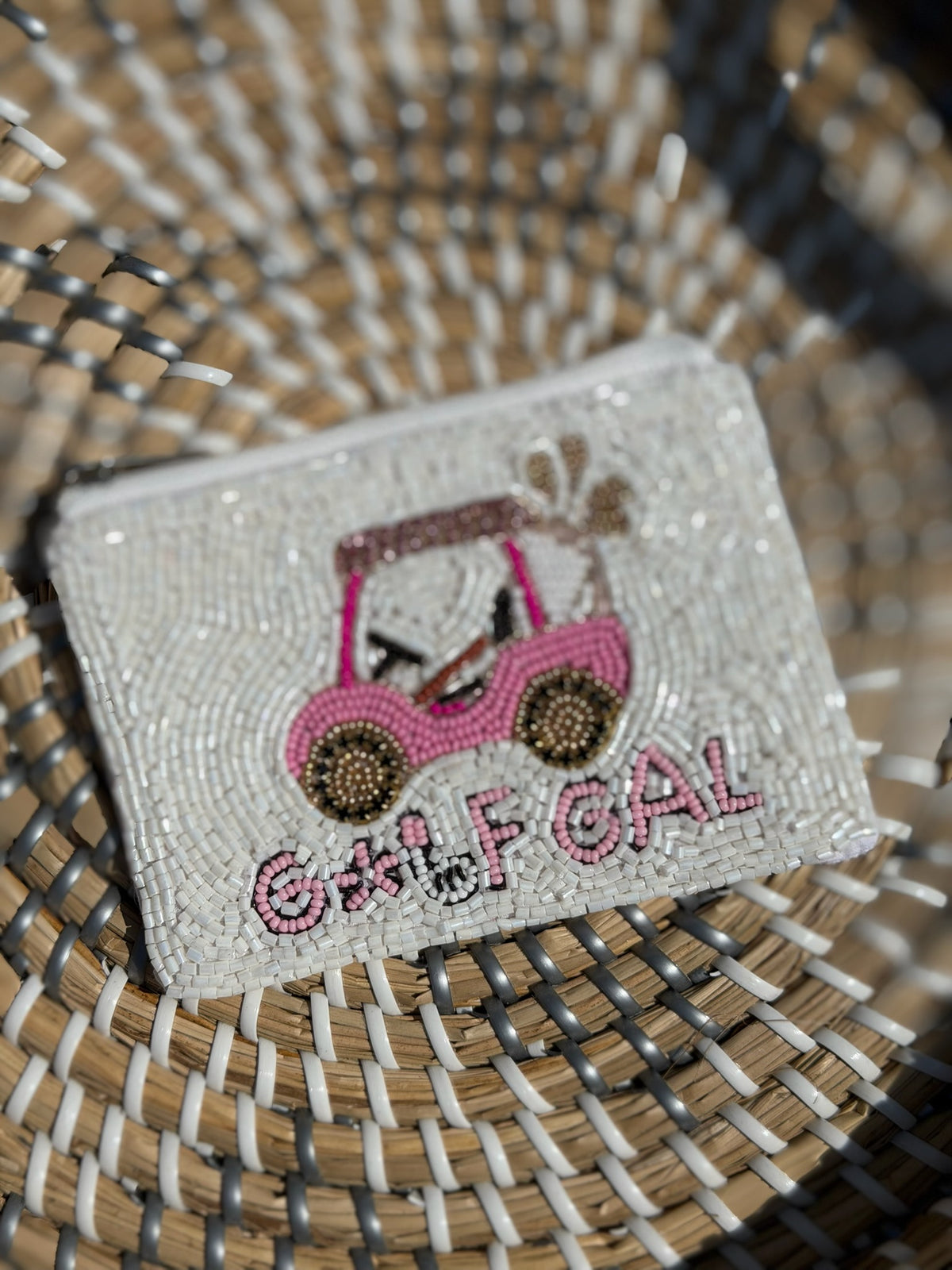 Small beaded purse with pink handbag design and 'Golf Gal' text on a woven surface