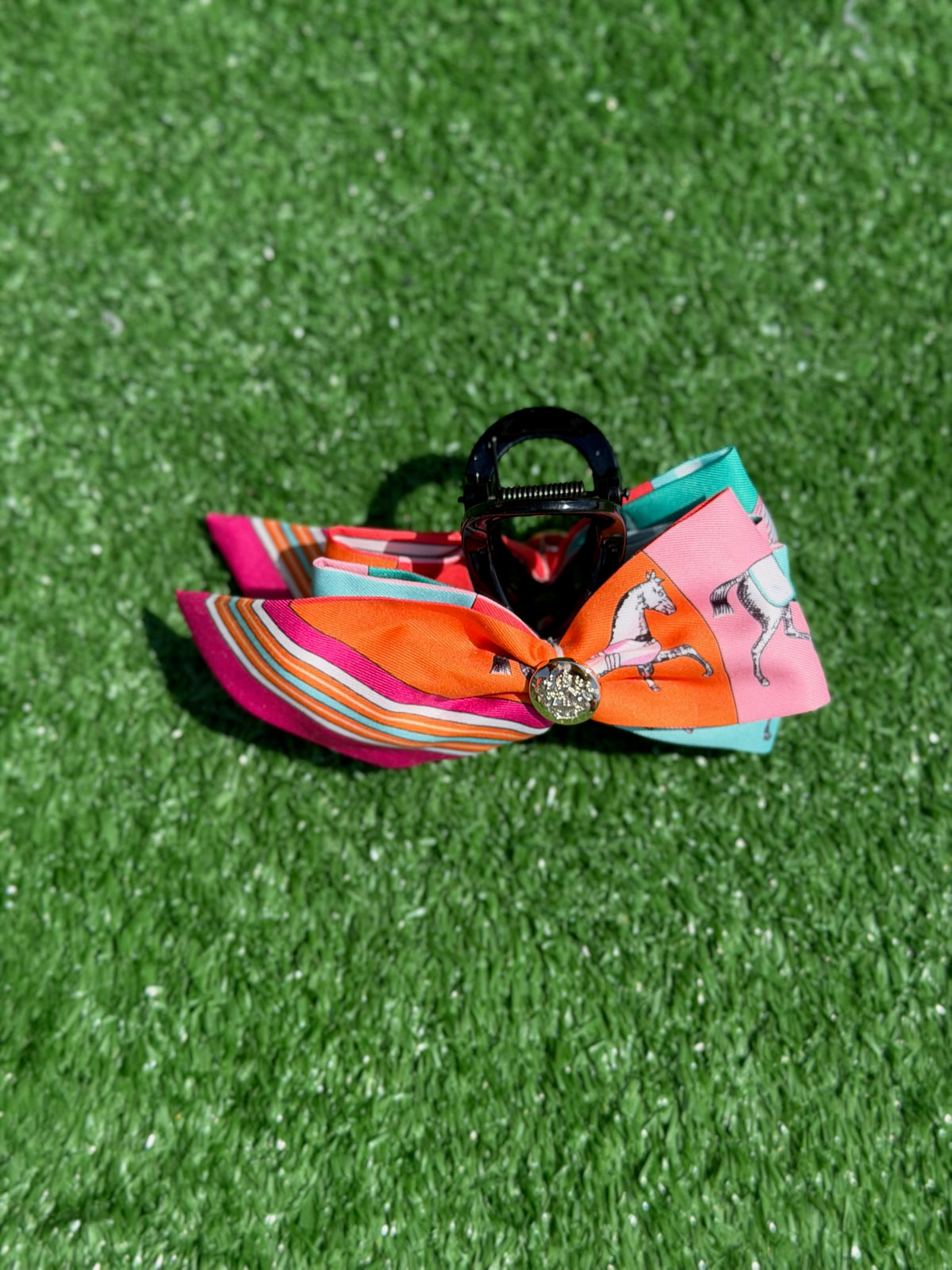Colorful bow hair clip on a green grass background